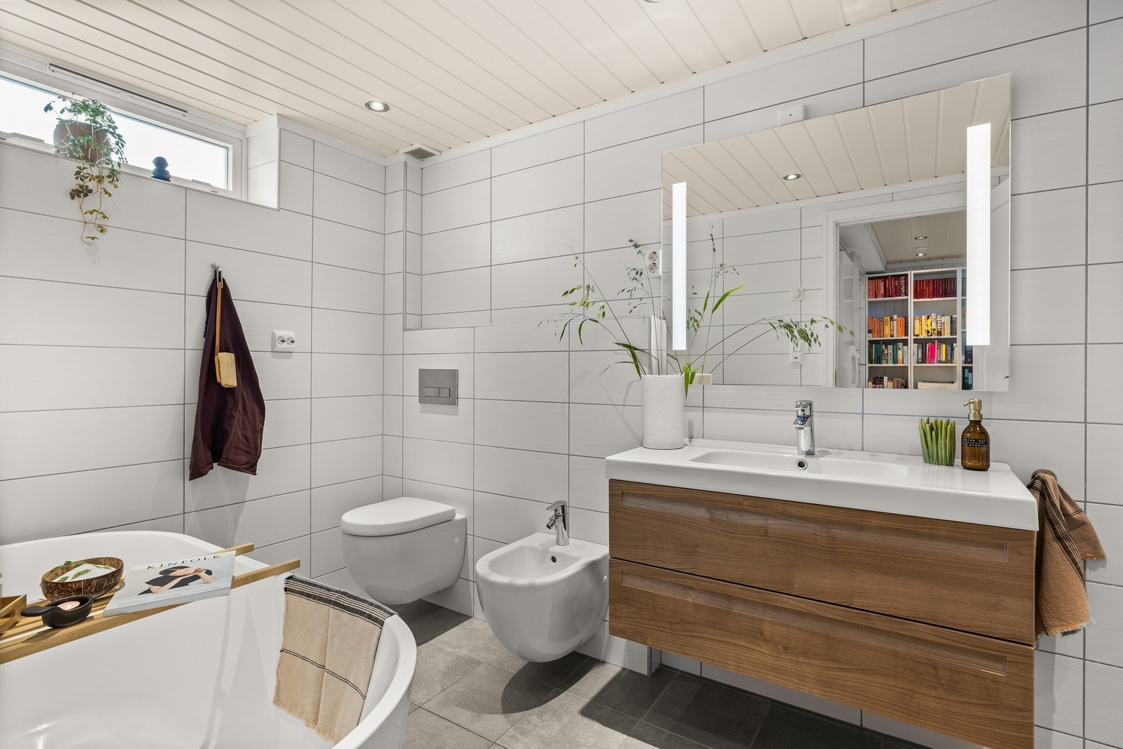 Stort og kombinert bad/vaskerom i kjelleren som ble pusset opp i 2013. Baderommet er utrustet med vegghengt servantskap med skuffer i glatte fronter. Speil med belysning over servant. Badekar med dusj, bidet og vegghengt toalett. Galleribilde