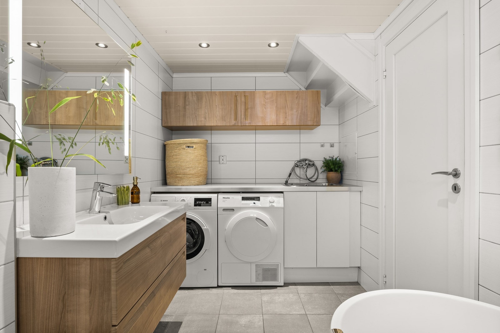I "vaskeromsdelen" er det benkeskap, vegghengt skap og laminert benkeplate med skyllekum i rustfritt stål. Opplegg til vaskemaskin og tørketrommel. Varme i gulv, downlights i tak. Galleribilde
