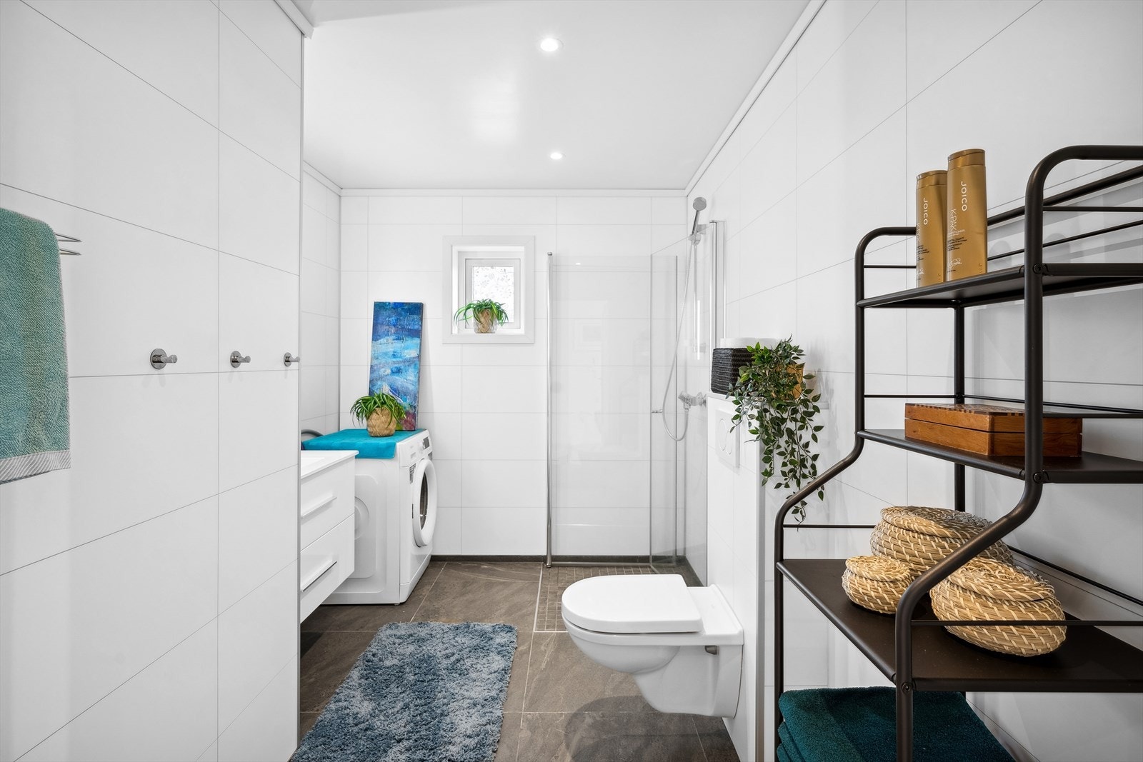 Badet er godt utstyrt med servant, toalett, dusj og opplegg for vaskemaskin Galleribilde