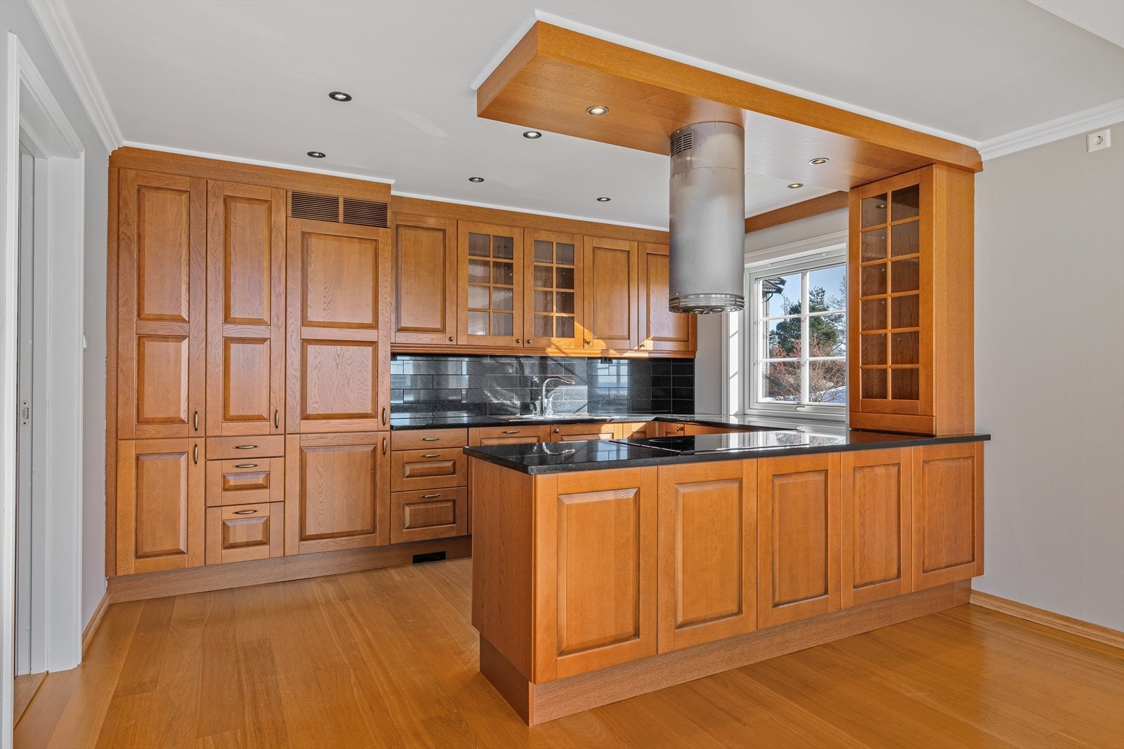 Delikat kjøkken med god skapplass og integrerte hvitevarer og stein benkeplater - Syd Galleribilde