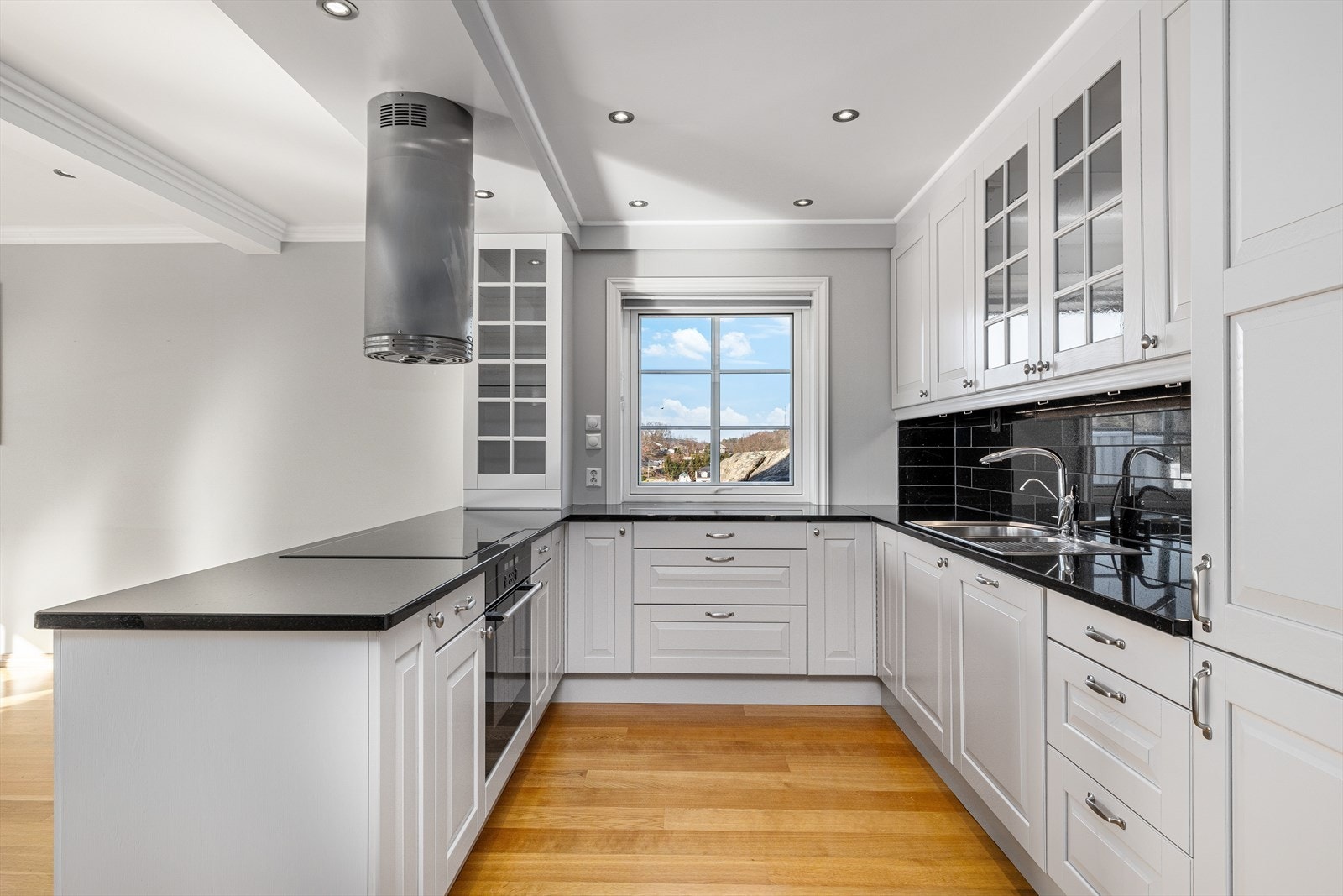 Kjøkken med god skapplass, integrerte hvitevarer og stein benkeplate - Nord Galleribilde