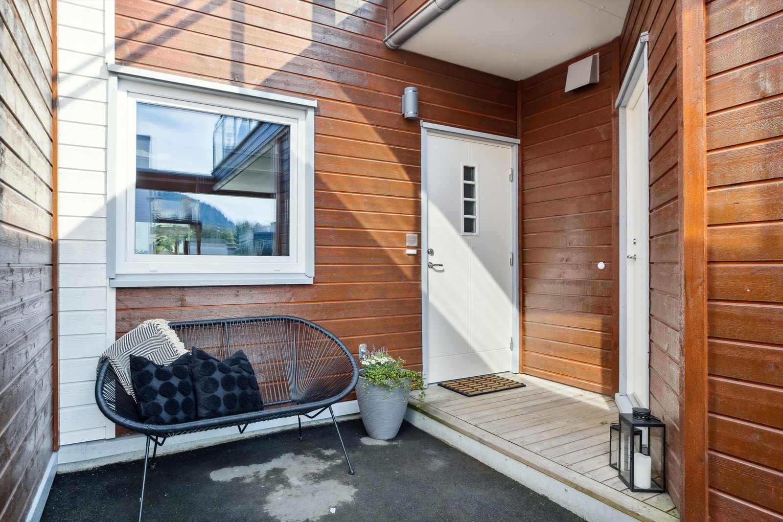 Rekkehuset har et trivelig, overbygd inngangsparti i tilknytning til carporten. På høyre hånd sees døren til den utvendige boden på 5 kvm. Galleribilde