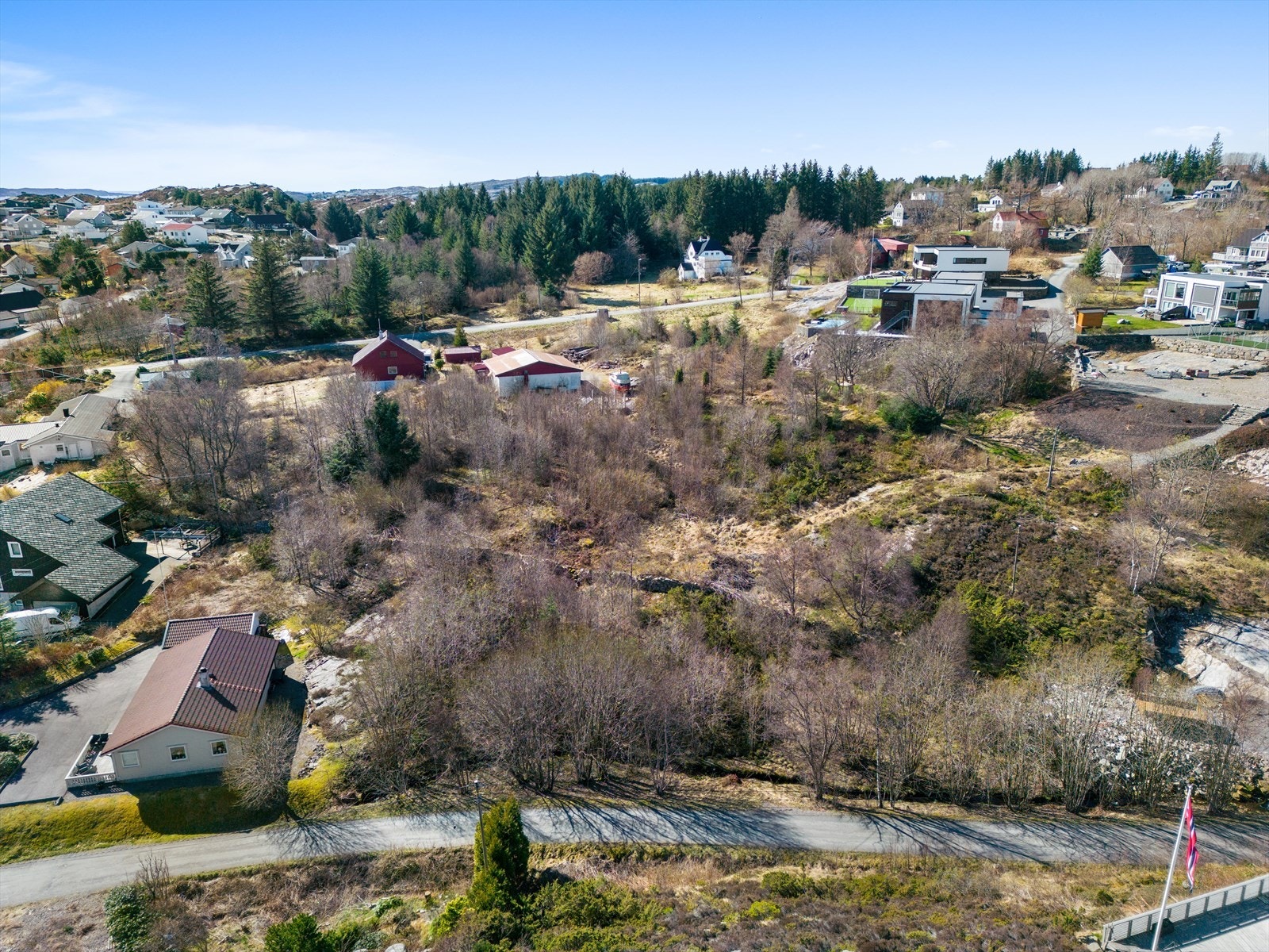 Tomten er i underkant av ett mål, og består primært av trær, kratt og andre buskevekster Galleribilde