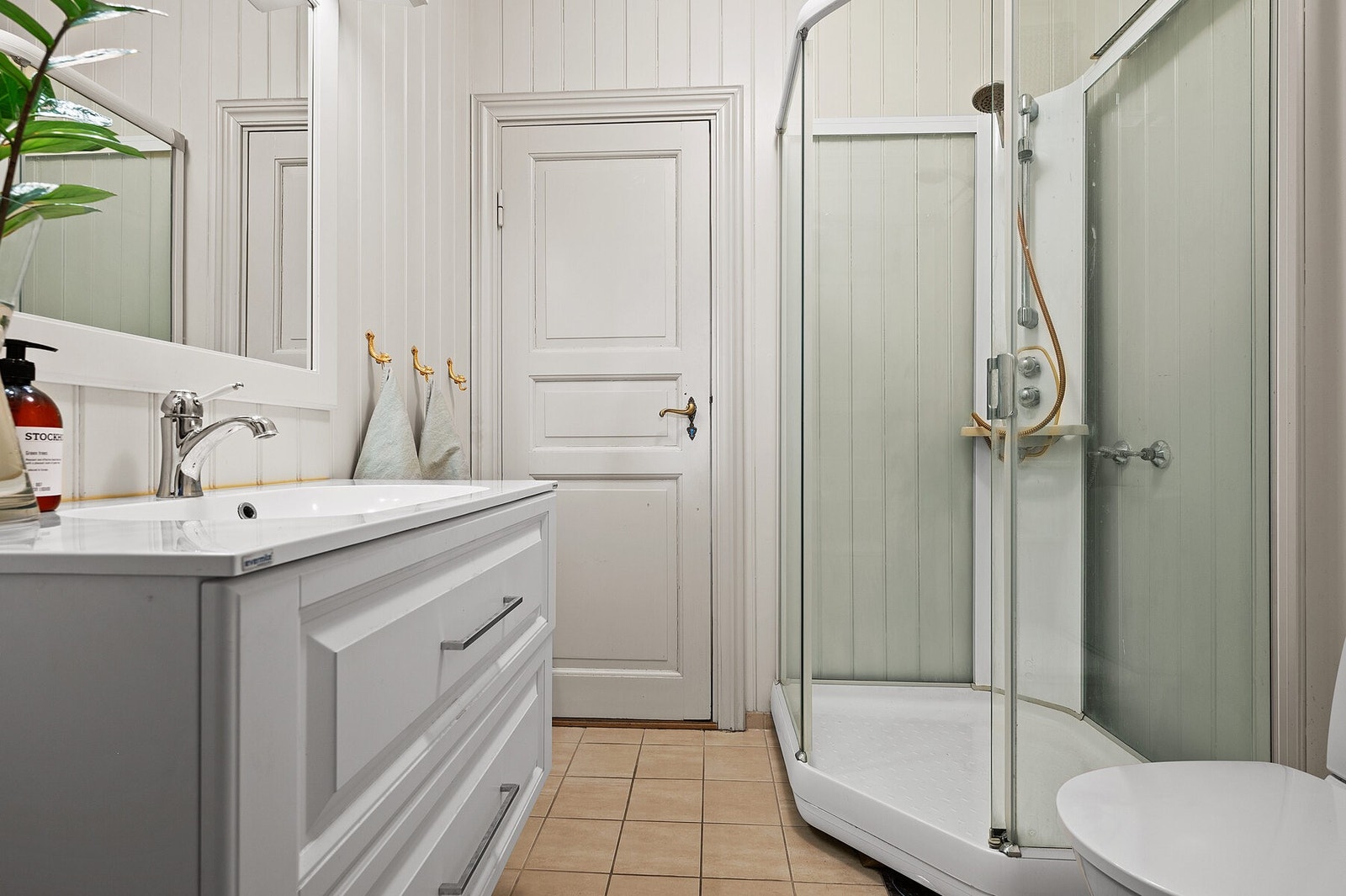 Gjennomgående bad fra soverom til gang. Det er dusjkabinett, servant og toalett Galleribilde