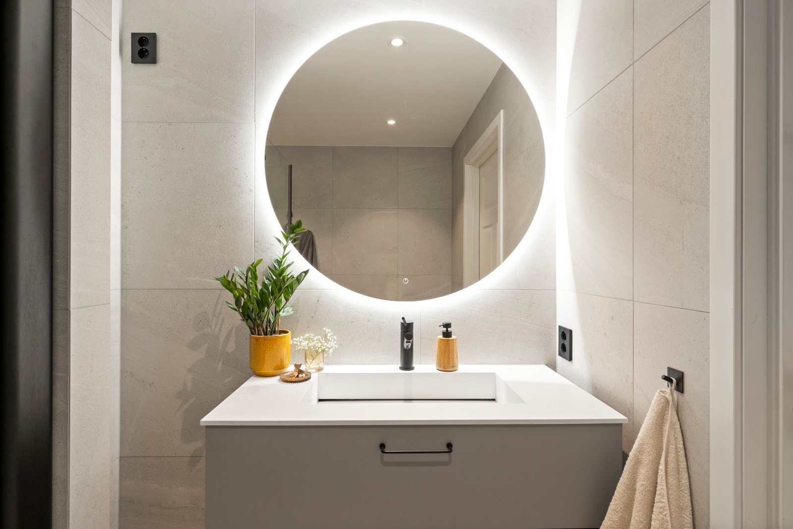 Badet ble totalrenovert i 2022, og har et stilrent uttrykk med store grå-beige fliser Galleribilde
