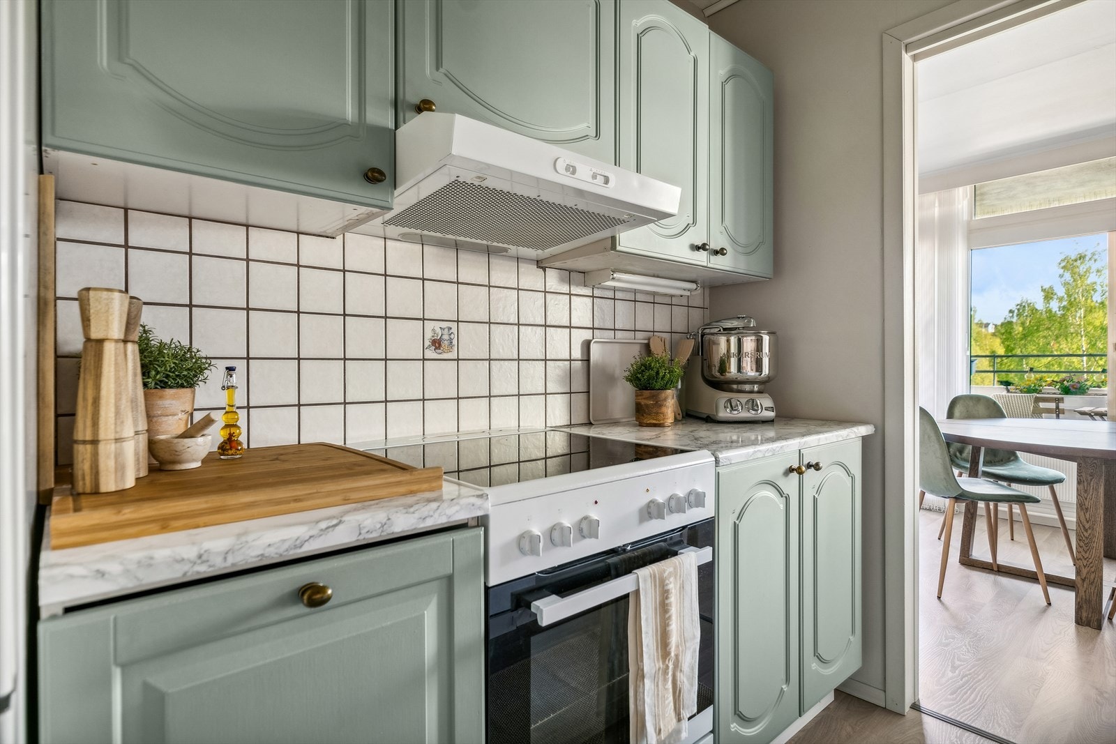 Kjøkkenet ligger praktisk plassert i et eget rom. Kjøkkeninnredning med malte profilerte fronter, laminerte benkeplater og nedfelt benkebeslag med oppvaskkum i rustfritt stål. Galleribilde