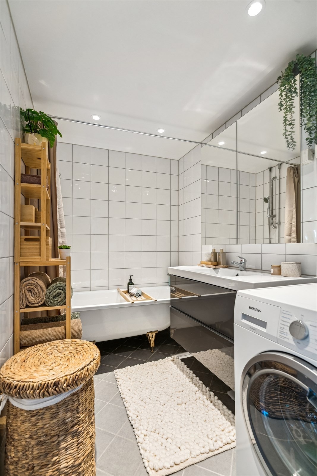 Badet er utstyrt med servantinnredning med grå høyglans laminerte fronter, heldekkende porselenservant, ettgreps servantarmatur og speilskap. Badet er videre utstyrt med badekar med dusjforheng, dusjbatteri og hånddusj. Galleribilde