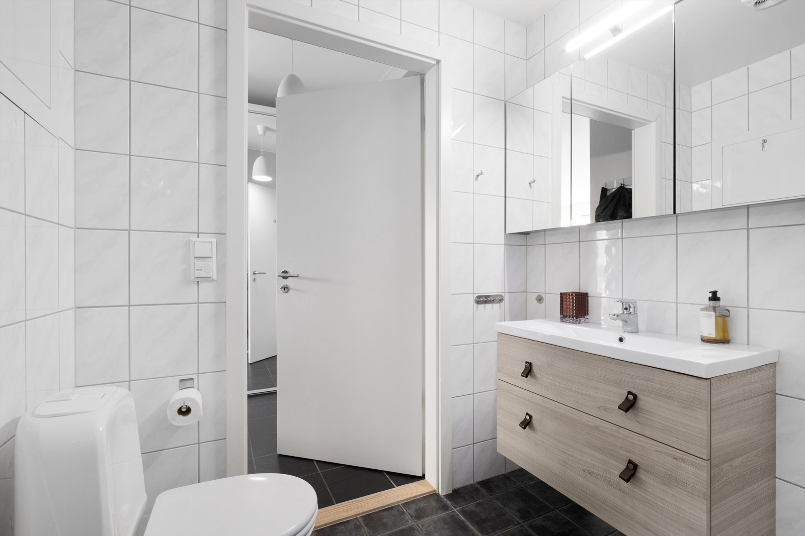 Innredet med dusjhjørne, møbel m/servant, tre speilskap, klosett og opplegg til vaskemaskin. Galleribilde