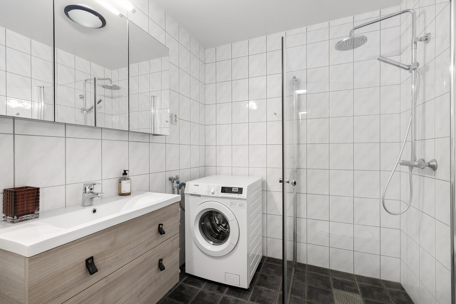 Delikat baderom med flis på gulv og vegger og tak i malte plater. Galleribilde