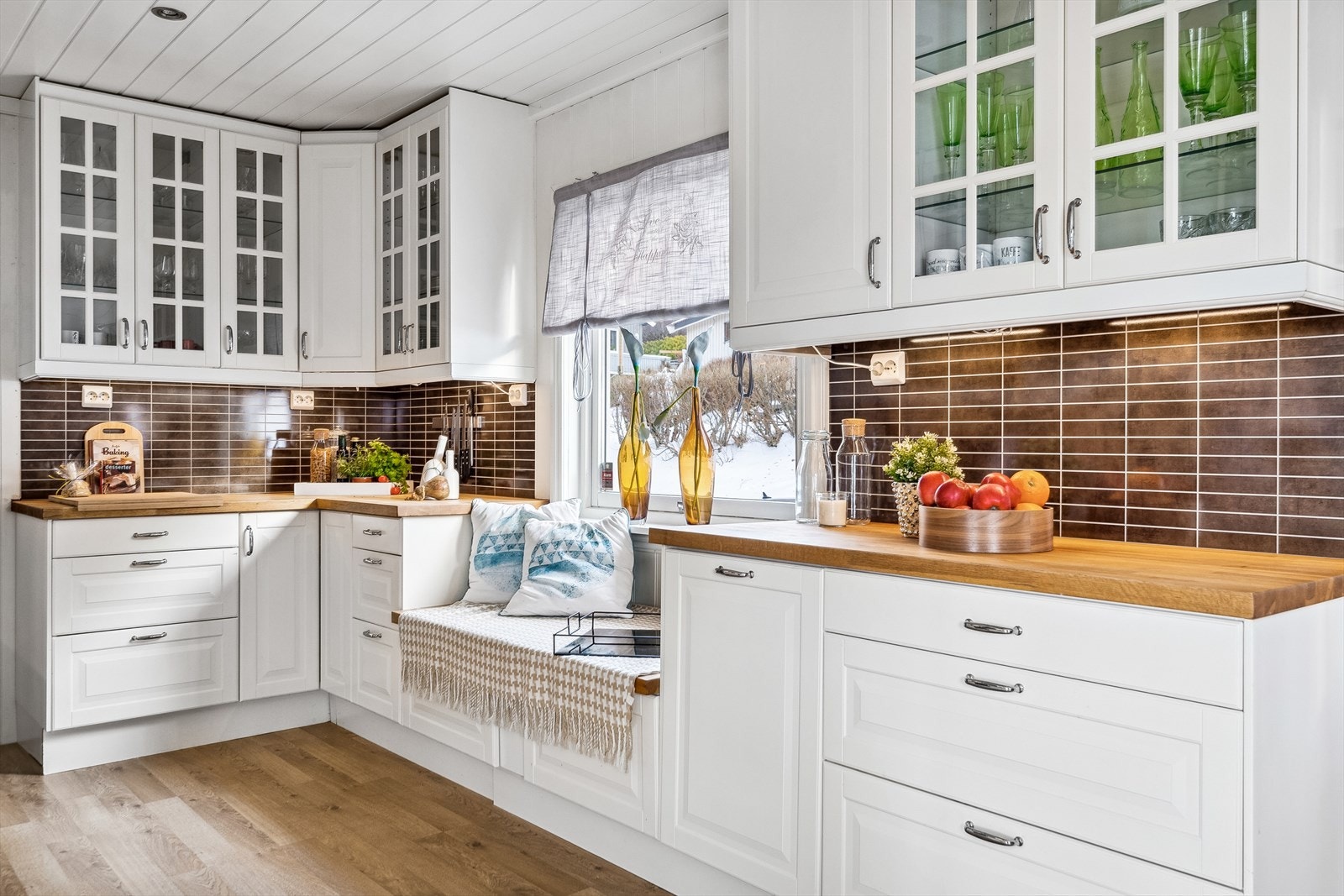 Under kjøkkenvinduet er det en koselig sitteplass med skuffer til oppbevaring. Galleribilde