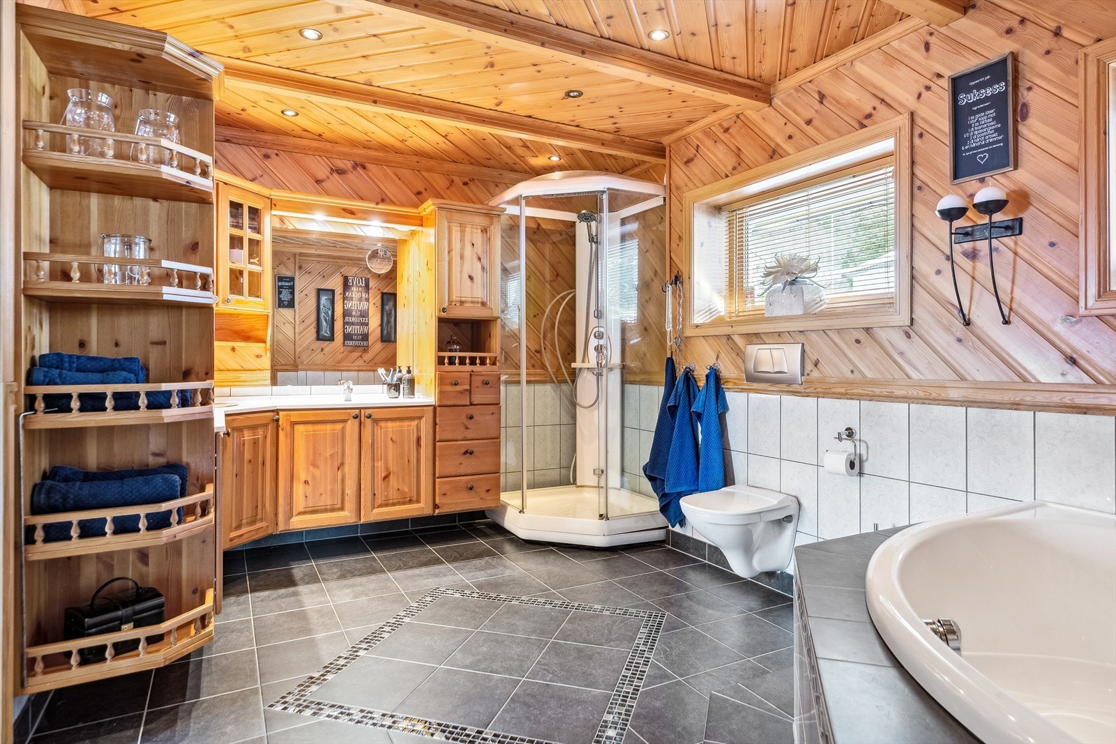 Badet har gulvvarme, en romslig innredning, toalett, dusjkabinett og et innfliset badkar. Galleribilde