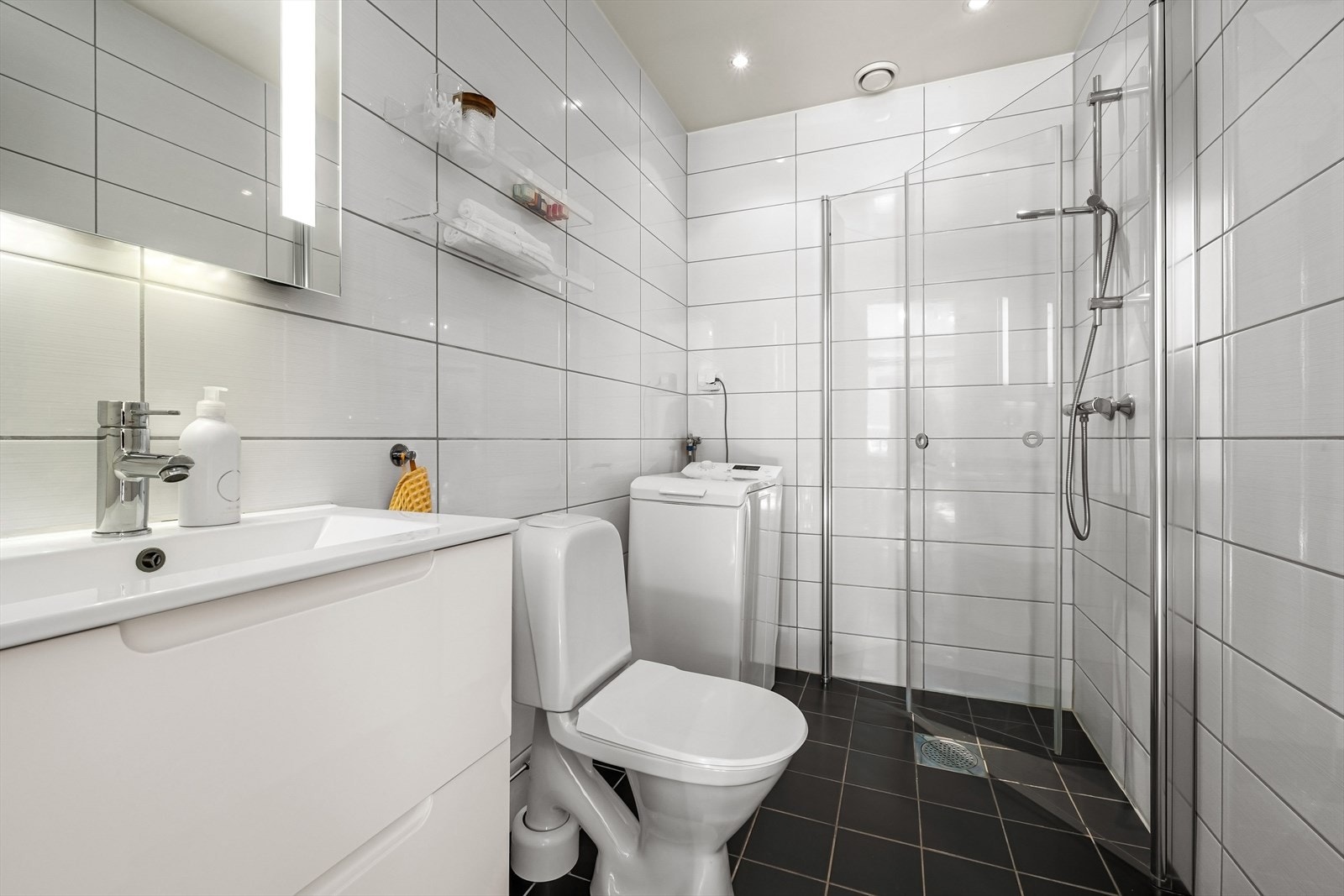 Stort bad med flislagte overflater, behagelig gulvvarme og downlights i himling. Det er opplegg for vaskemaskin Galleribilde