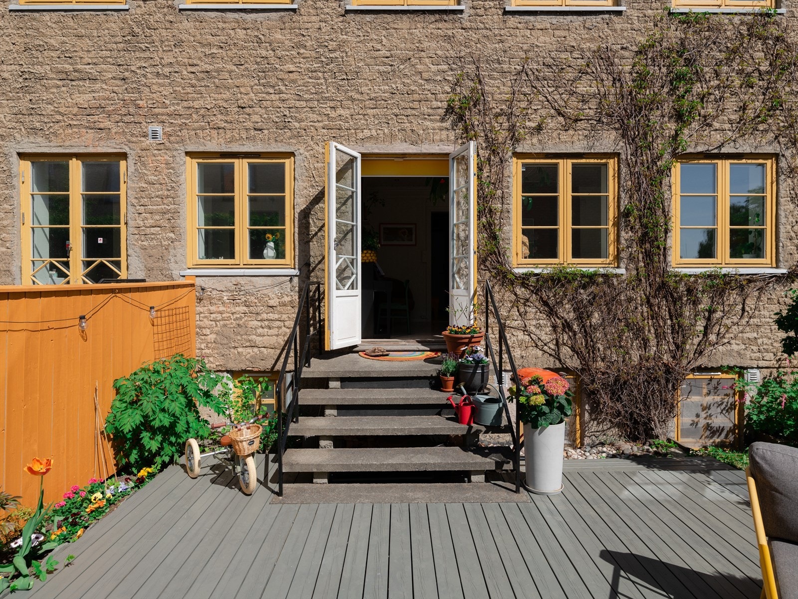 Direkte utgang til hageparsell med beplantning og praktisk platting - fine solforhold. Galleribilde
