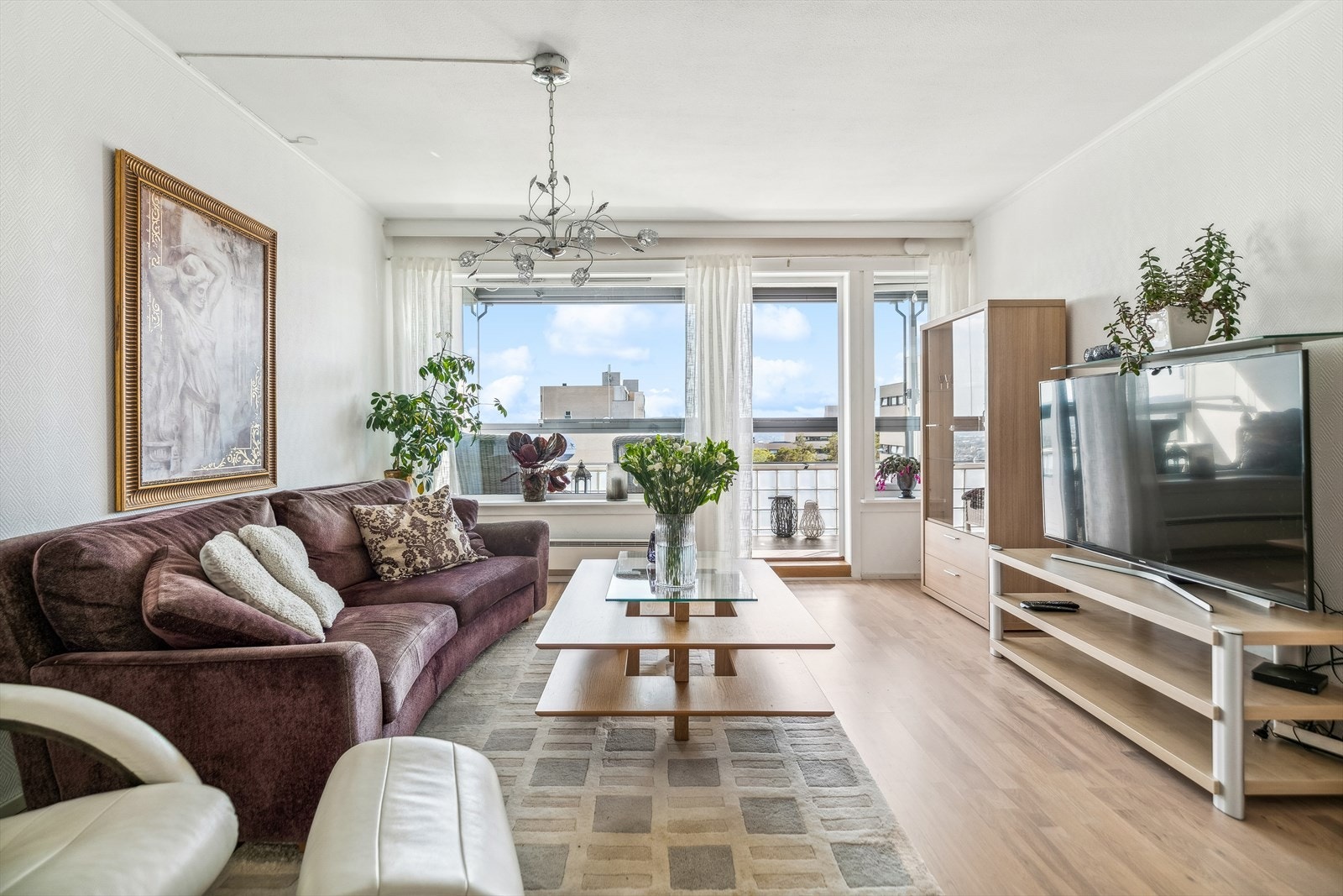 Lys og romslig stue som inviterer til avslapning og hyggelige stunder med familie og venner. De store vindusflatene skaper en åpen og luftig atmosfære. Galleribilde