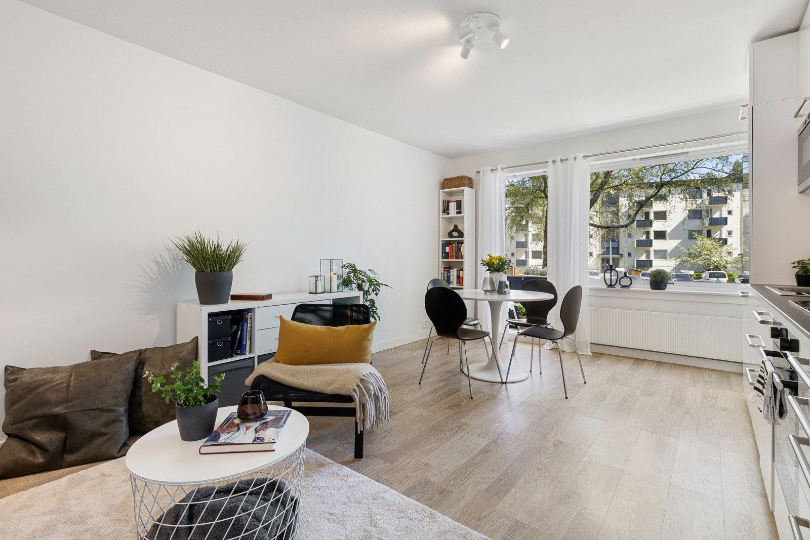 Stuen har et stort vindu og en balkongdør i glass som gir rommet rikelig med naturlig lys og et hyggelig utsyn. Galleribilde