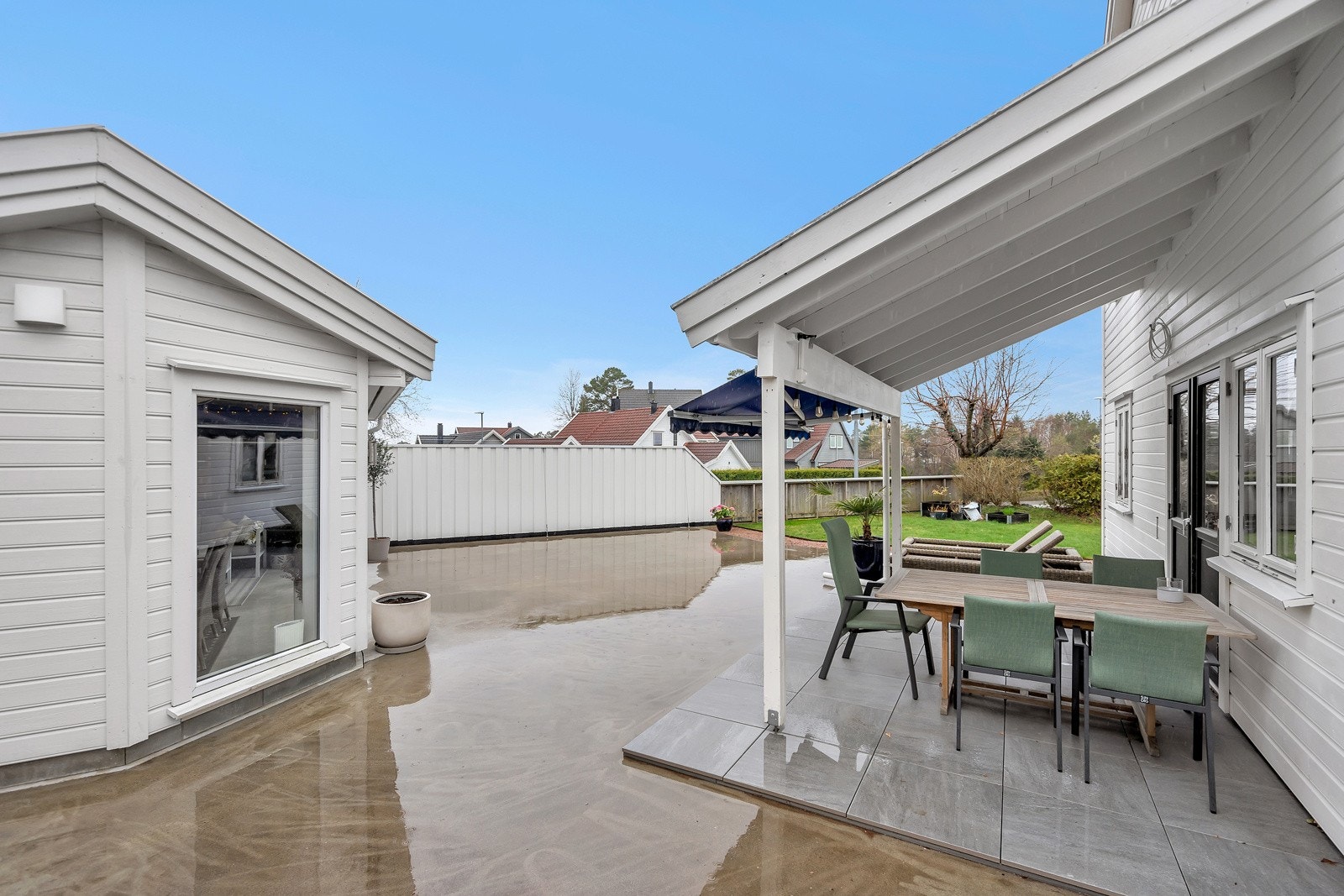 Stor lettstelt hage med støpt platting og gressplen Galleribilde