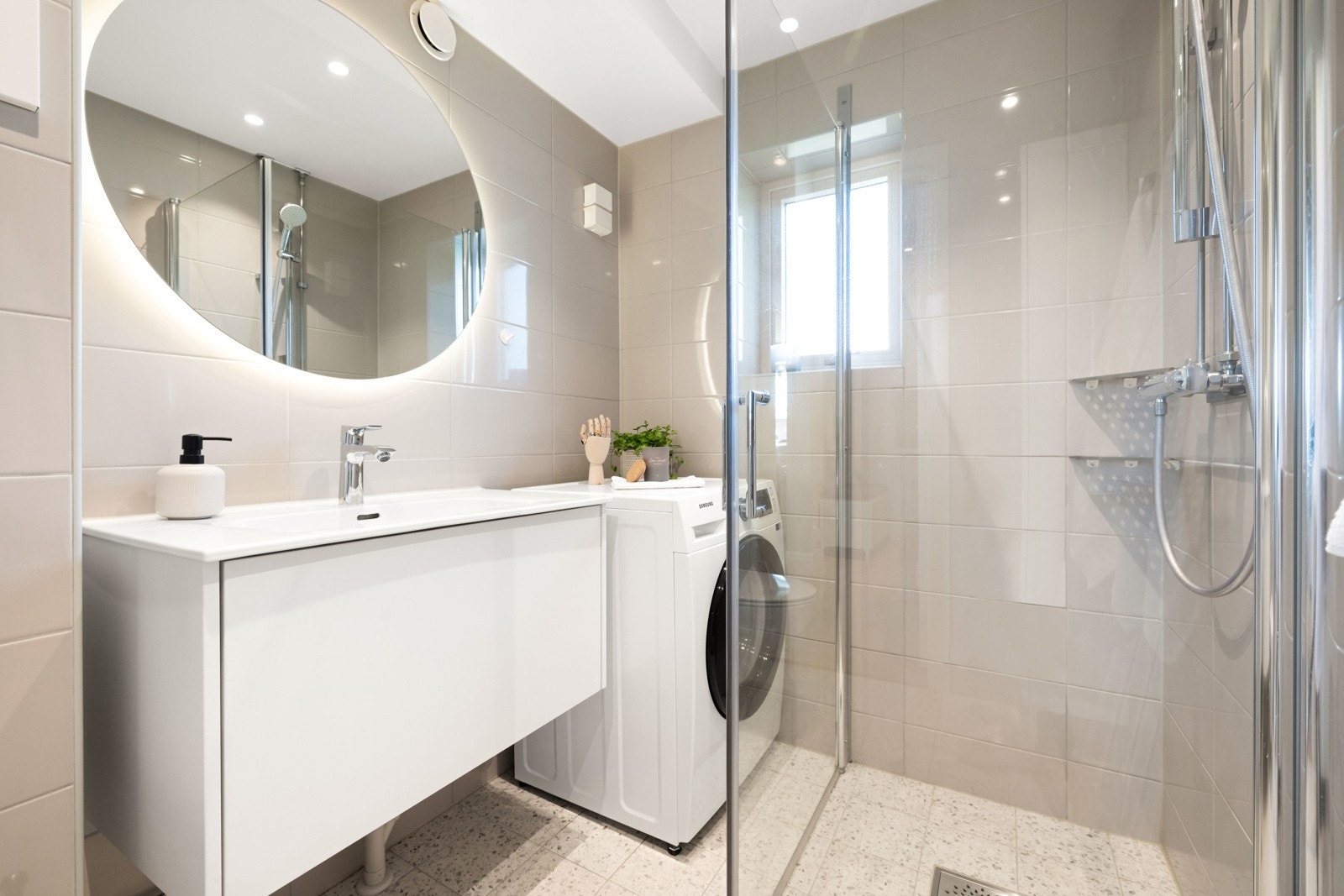 Badet, som ble oppusset i 2021, fremstår som moderne og delikat med flislagte gulv med gulvvarme og matchende flislagte vegger Galleribilde
