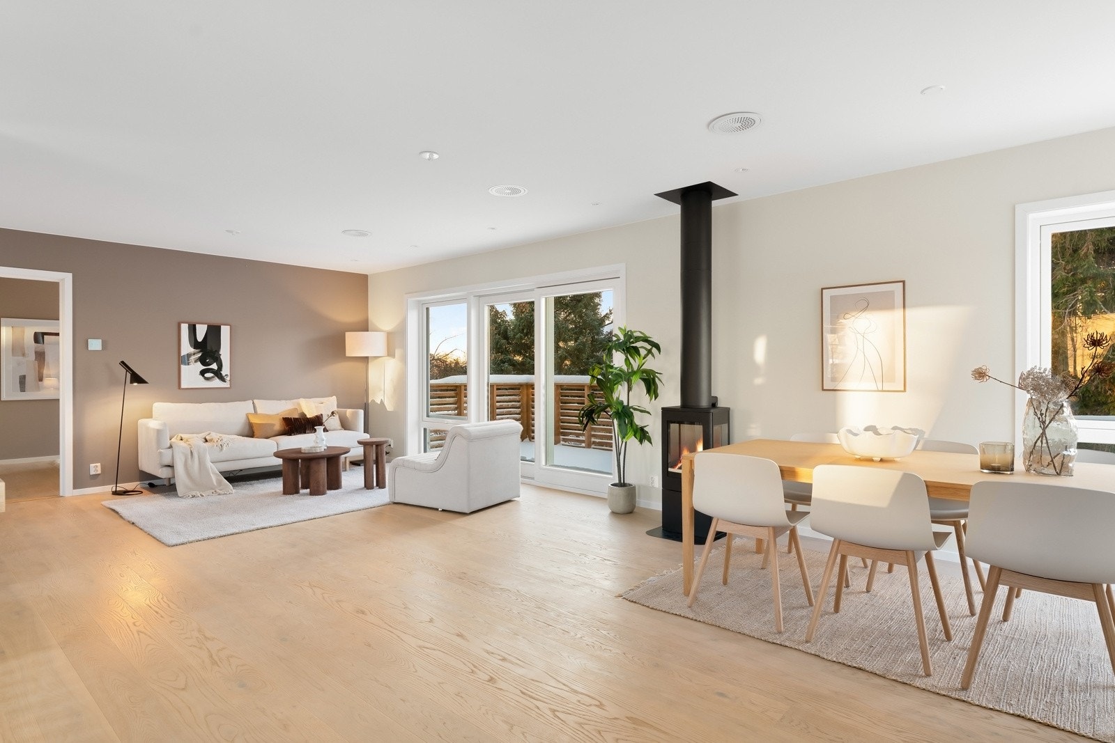 Lys og åpen stue og spisestue med utgang til solrik balkong Galleribilde