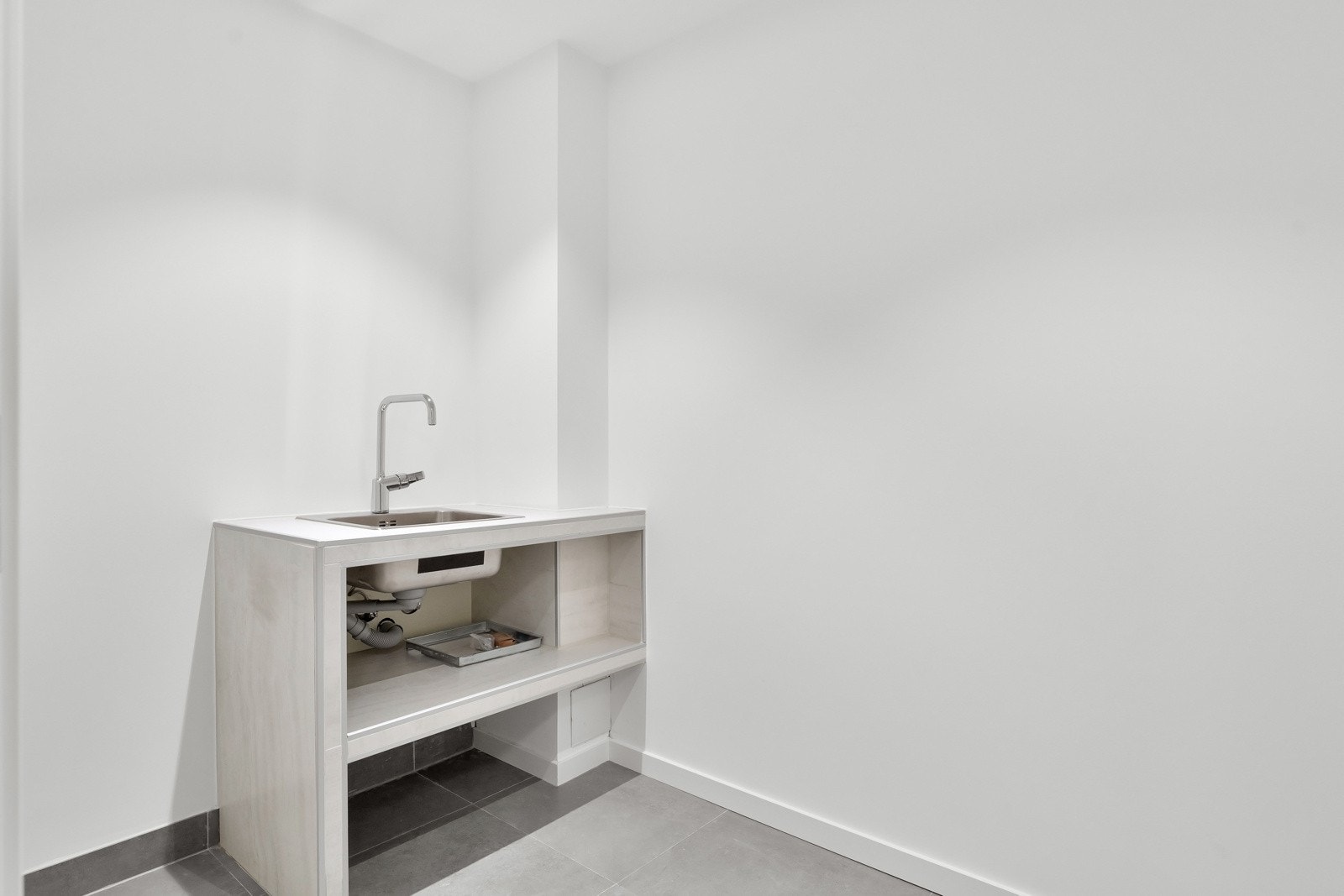 Praktisk separat vaskerom innredet med plassbygget hylleseksjon med planlimt kum. Galleribilde