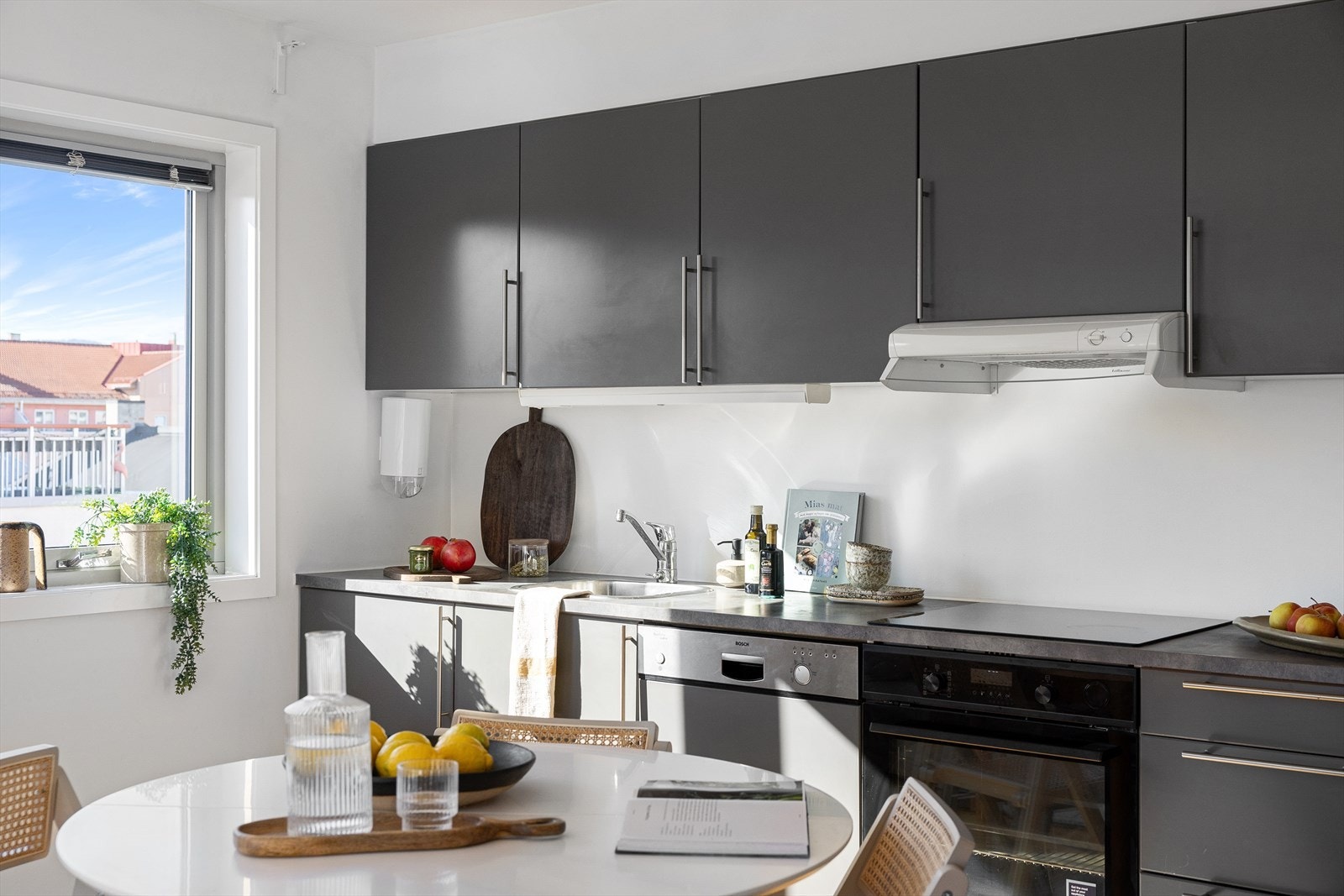 Kjøkkenet har innredning med slette fronter i en grå farge og laminat benkeplate. Galleribilde