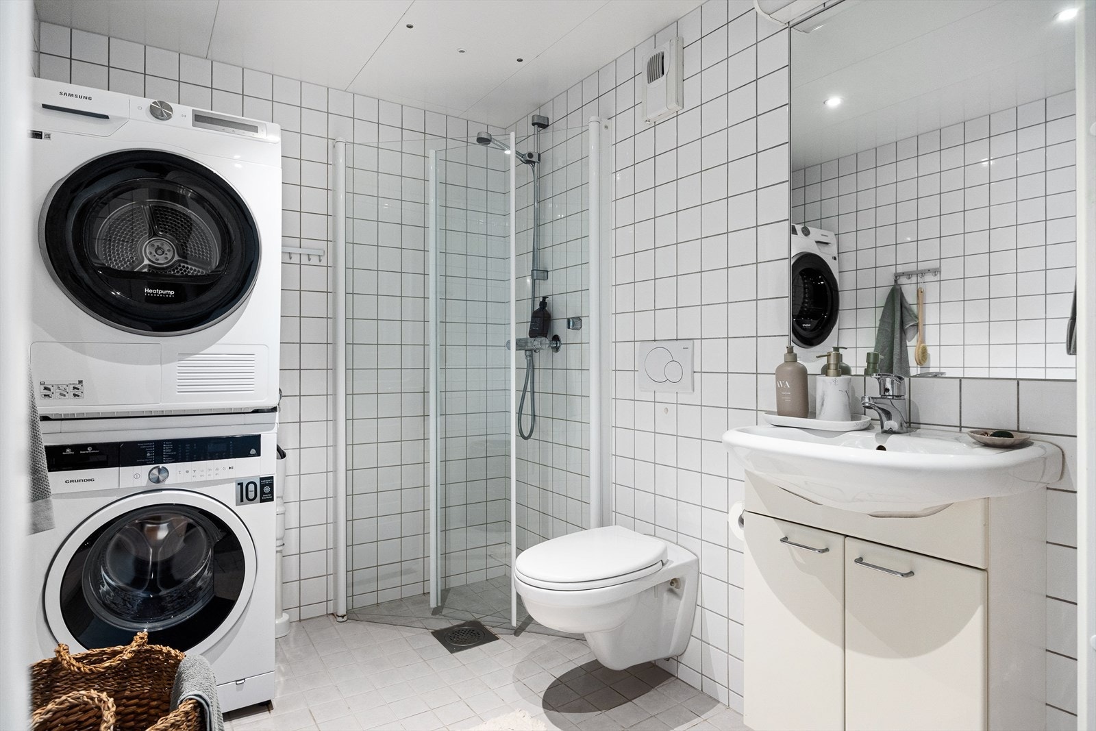 Av baderomsinnredning er det vegghengt klosett, servantinnredning, dusj på gulv med innfellbare glassdører og speil og lys på vegg. Galleribilde