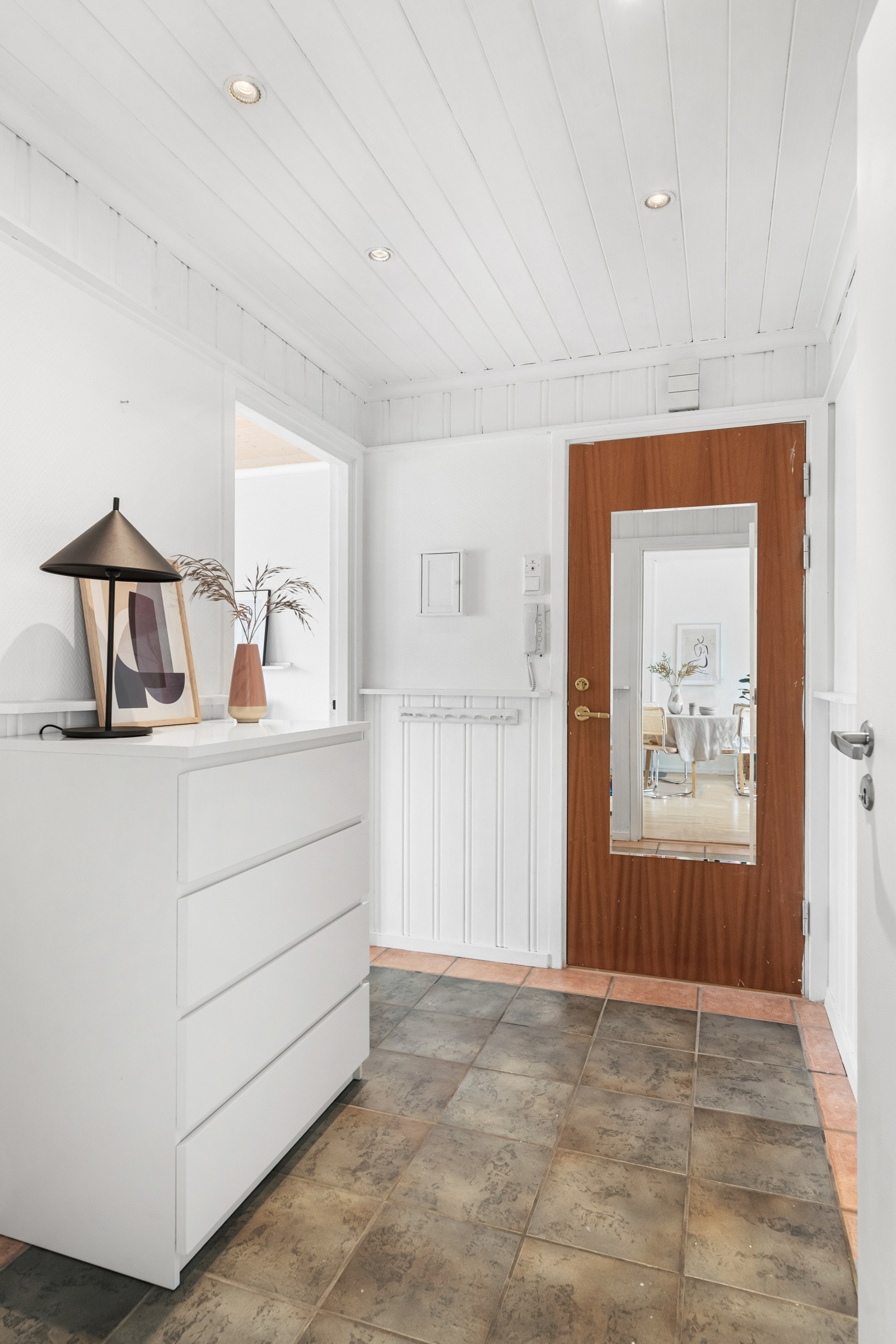 Fin entré med flislagt gulv og downlights i himling. Ved siden av brann- og lydklassifisert entrédør er det montert callinganlegg med døråpner. Galleribilde