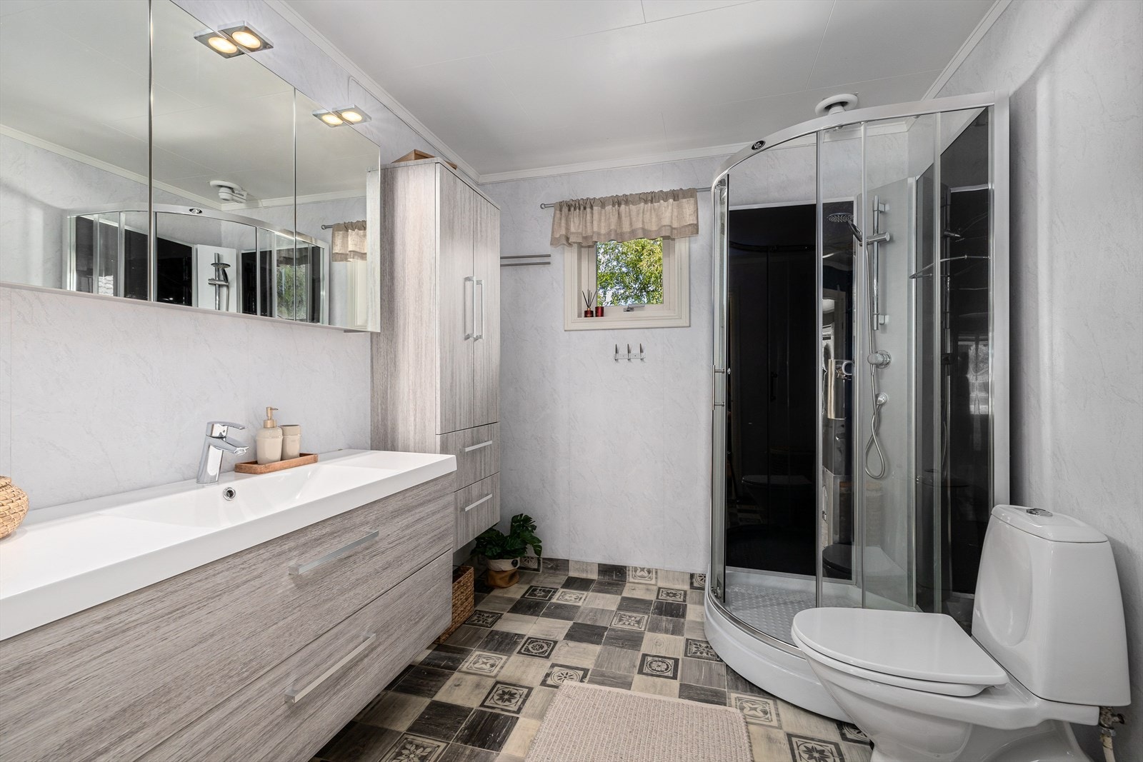 Baderom med vinylbelegg og gulvvarme, baderomstapet på vegger og malt himlingsplater. Galleribilde