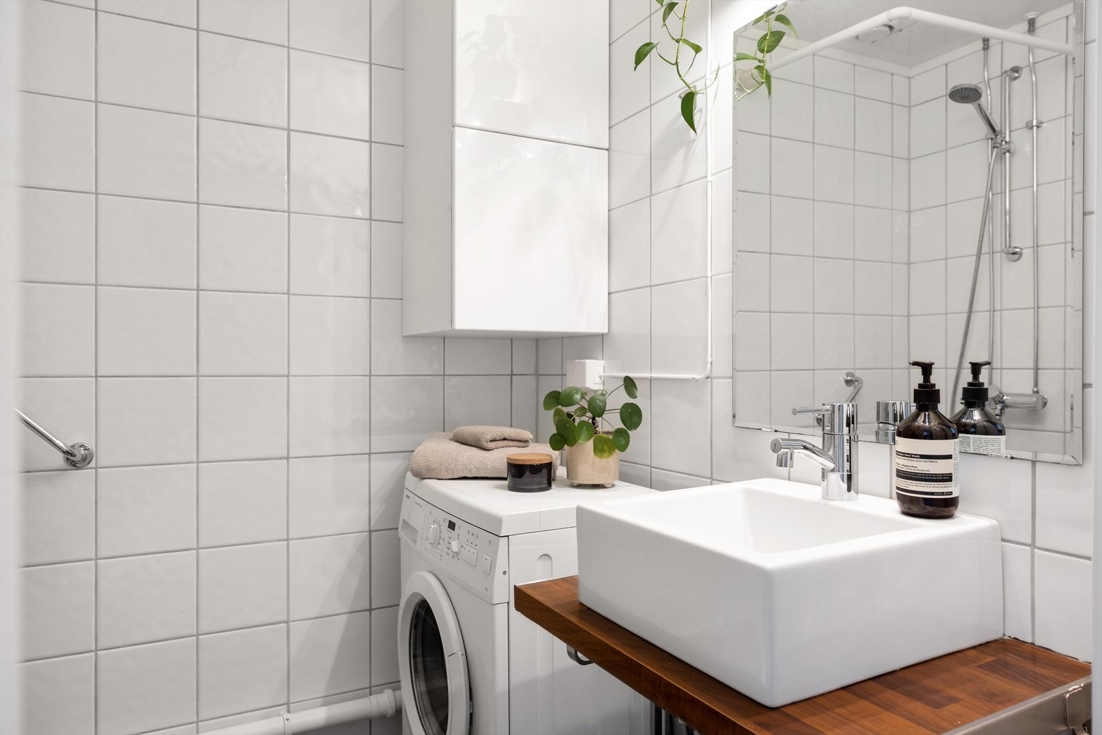 Badet er innredet med vegghengt klosett, servant på benkeplate, speil og dusjhjørne. Det er opplegg for vaskemaskin. Galleribilde