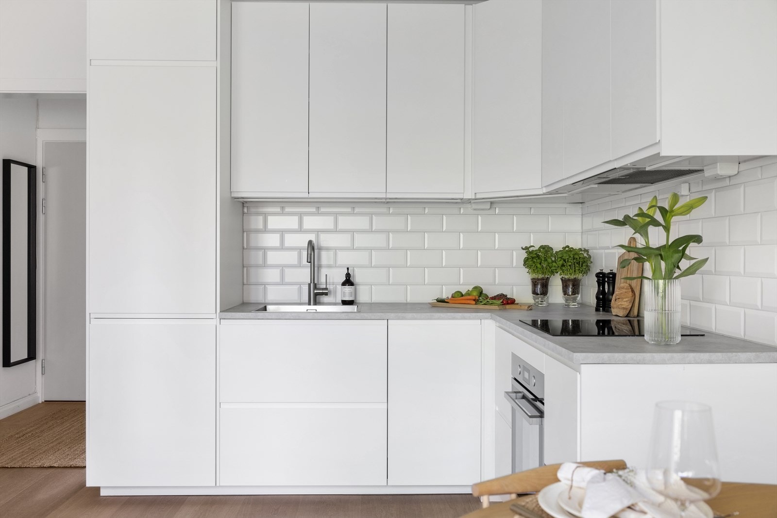Kjøkkenet har glatte fronter, laminat benkeplate med nedfelt vaskekum, samt fliser og belysning over benkeplaten. Galleribilde