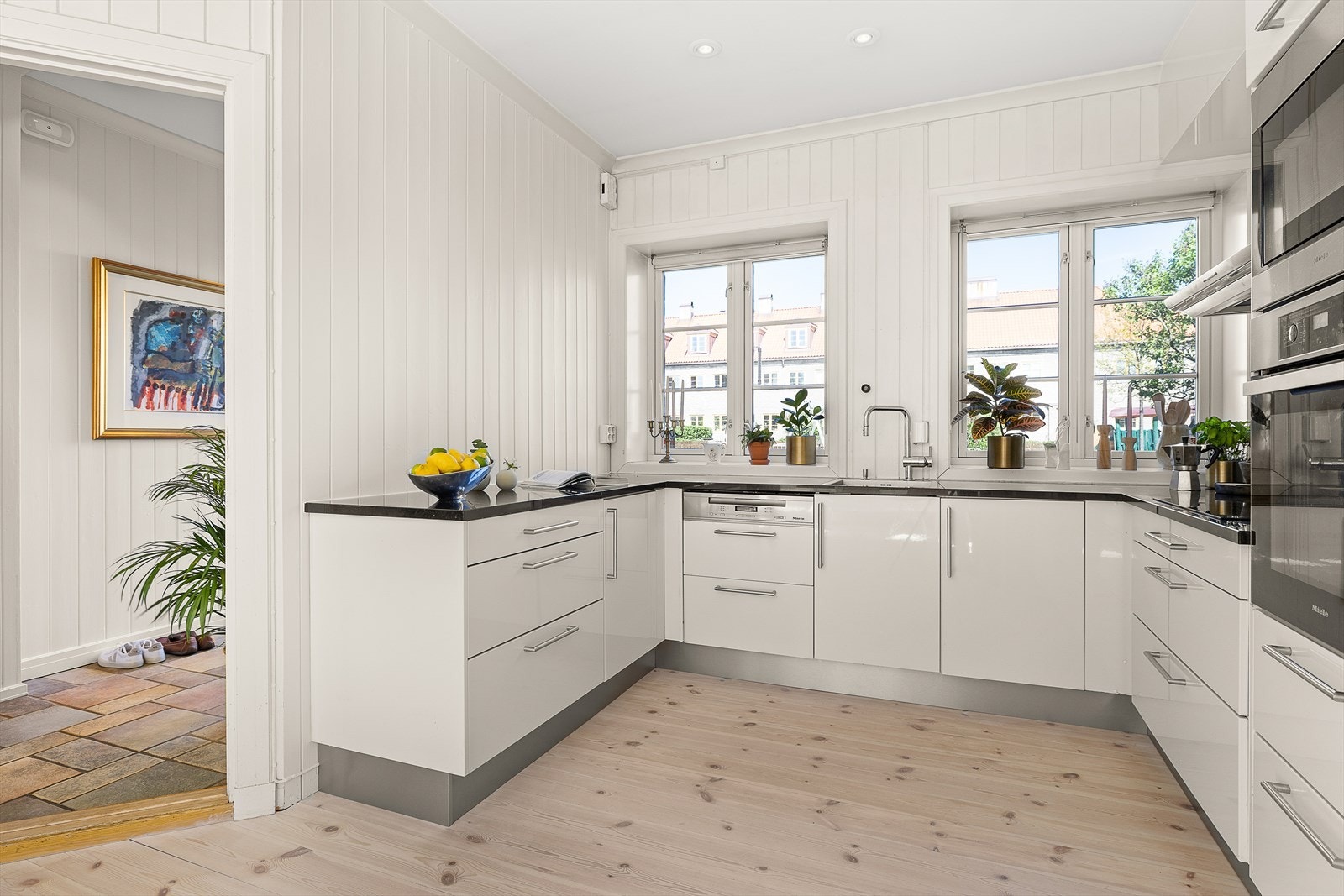 Hvite/høyglansede fronter med granitt benkeplate og planlimt oppvaskkum.
Integrerte hvitevarer som oppvaskmaskin. stekeovn/koketopp. kjøl/frys. micro-ovn. Galleribilde
