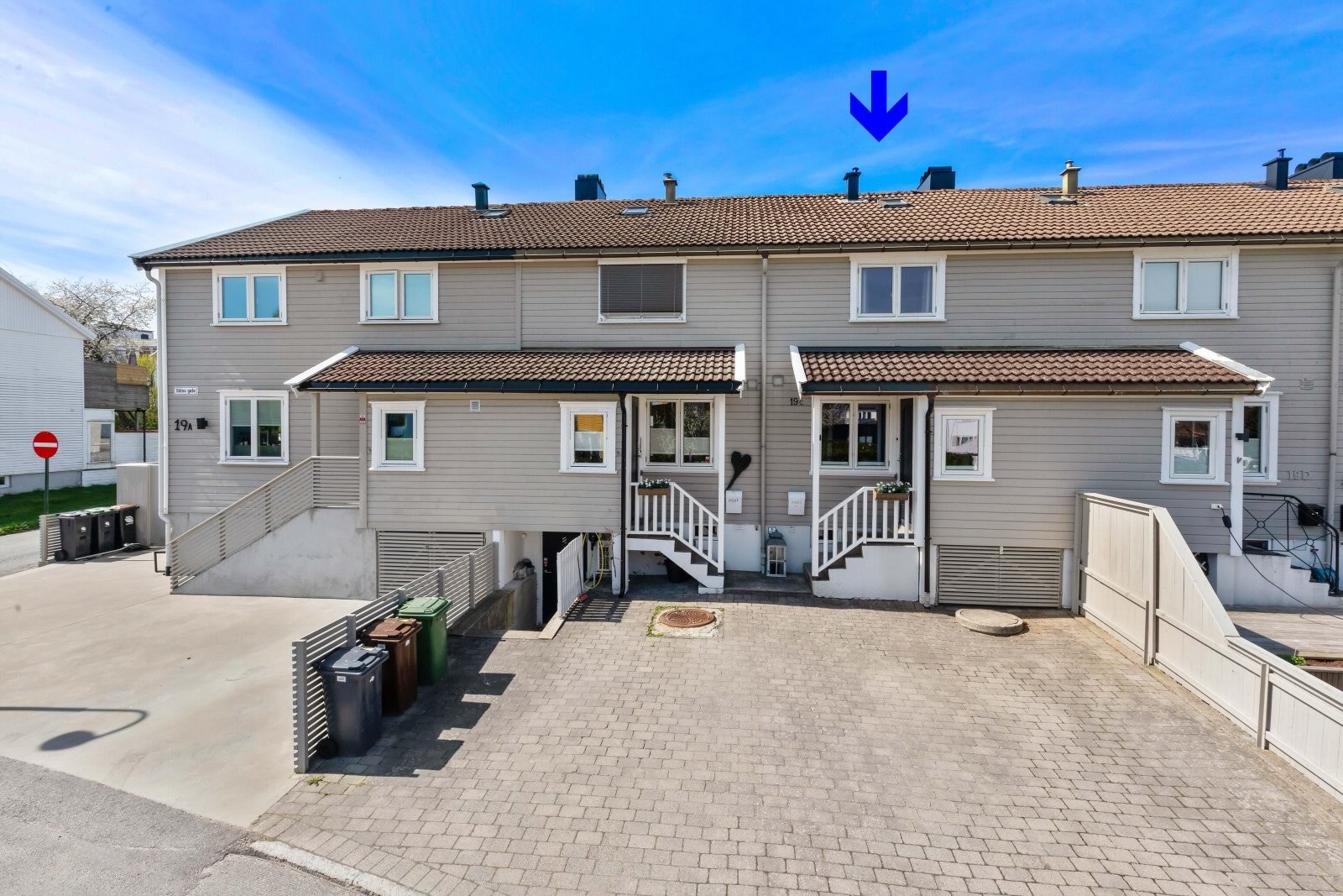 Steinlagt gårdsplass til parkering like ved boligens inngangsparti. Galleribilde
