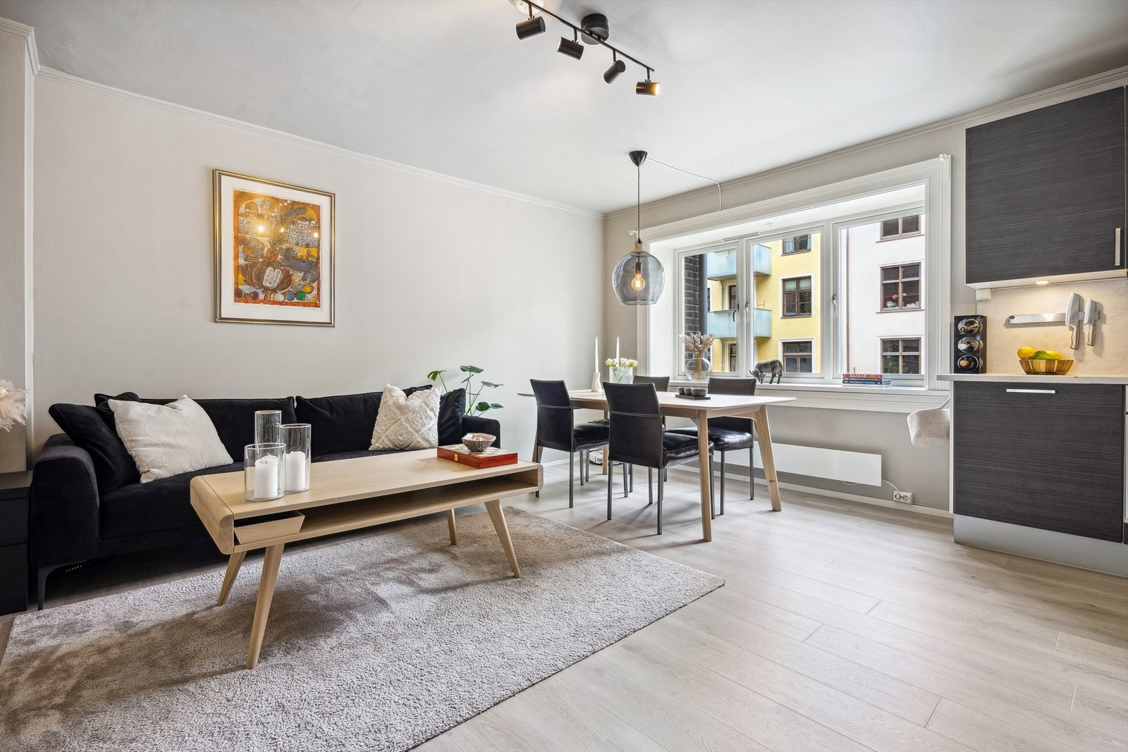 En fin leilighet som er omgjort fra 1-roms til 2-roms gjennom at man har flyttet inn kjøkkenet i stuen Galleribilde