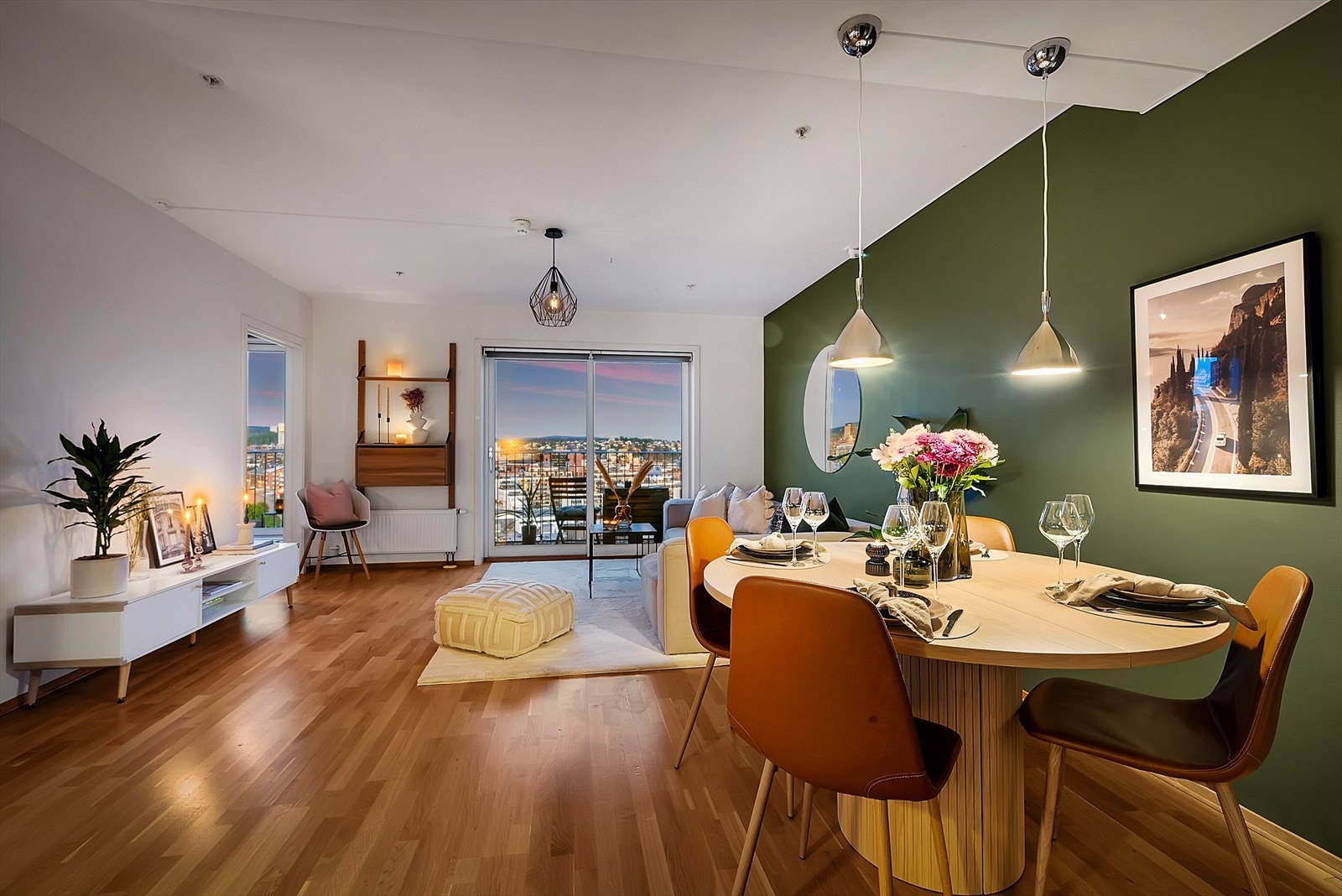 En magisk atmosfære på kveldstid, med byens funklende lys inn gjennom vinduene og vakkert fargespill på himmelen Galleribilde