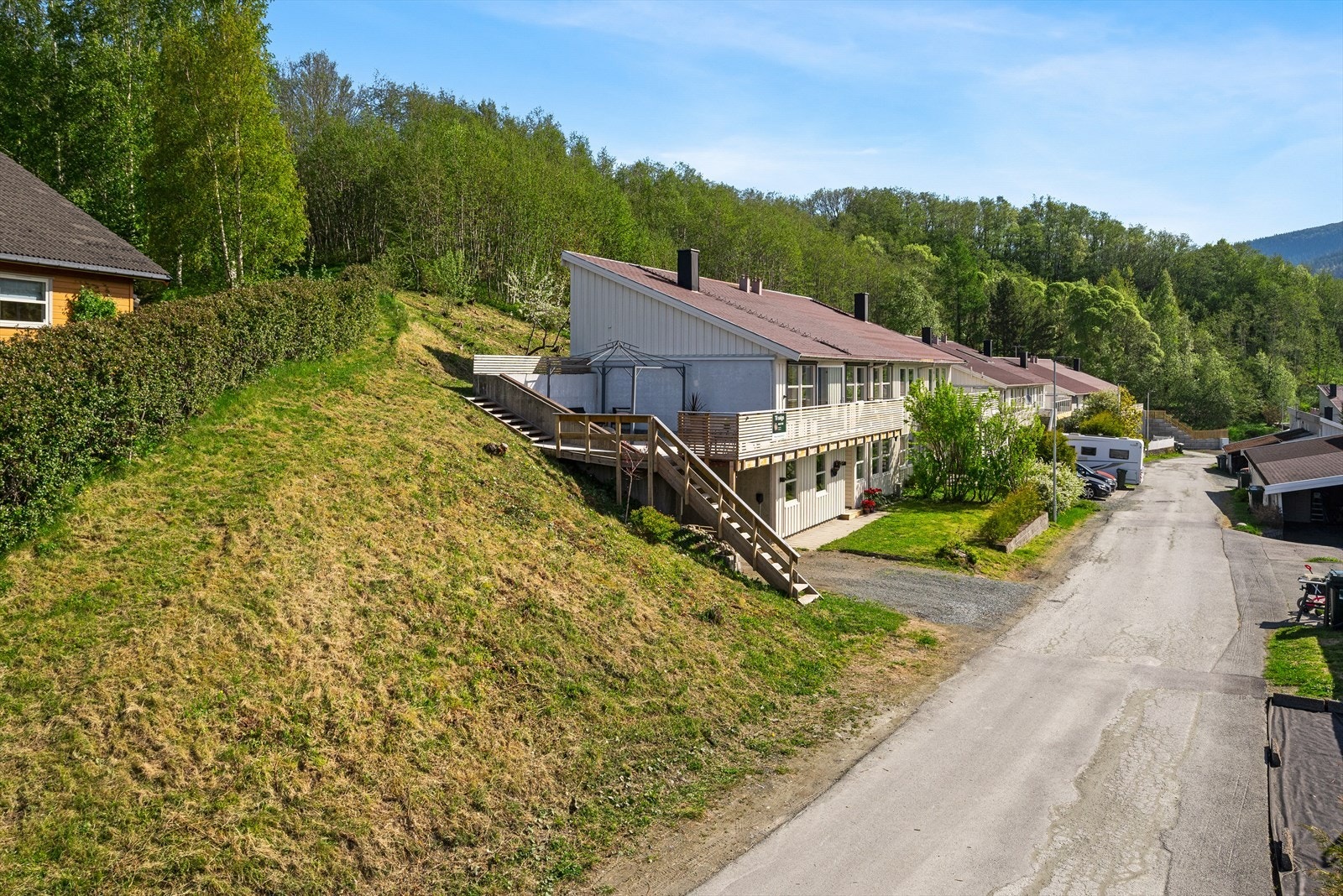 Utenfor stuen i første etasje ligger en stor terrasse som er tilknyttet veranda i forkant av boligen. Galleribilde