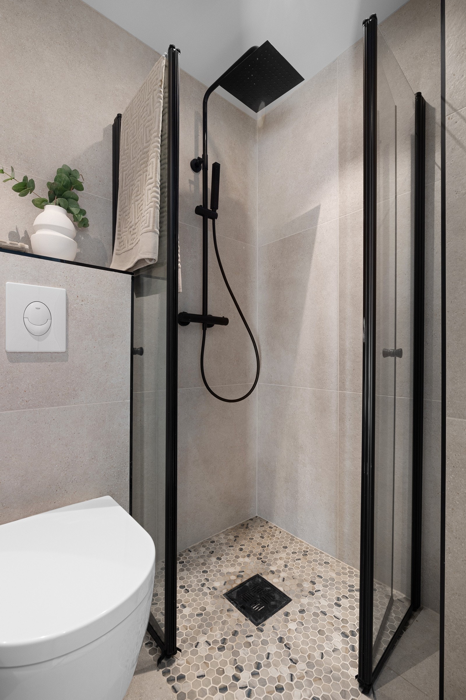 Romslig dusjhjørne med regnfallsdusj og glassdører. Fin helhet med lekre, matchende detaljer. Galleribilde