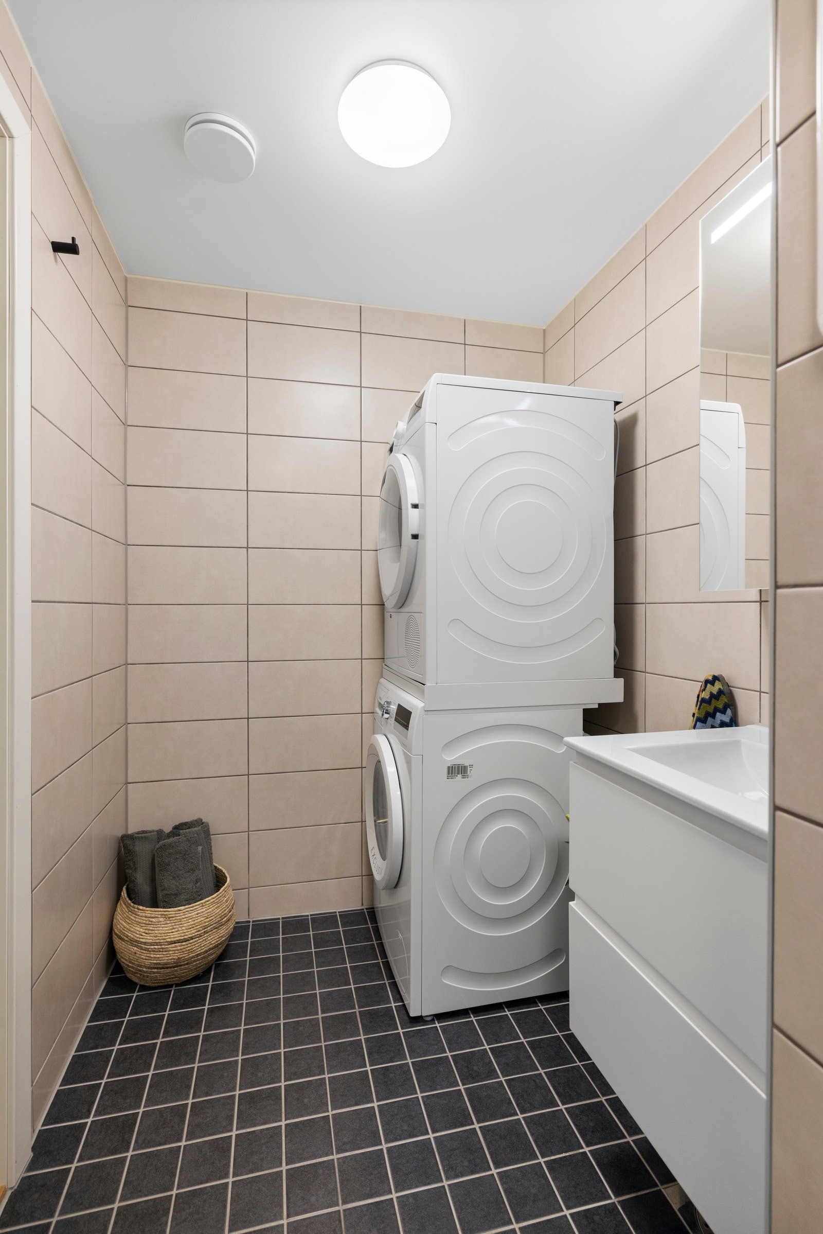 Videre har badet et vegghengt toalett og opplegg for vaskemaskin/tørketrommel Galleribilde