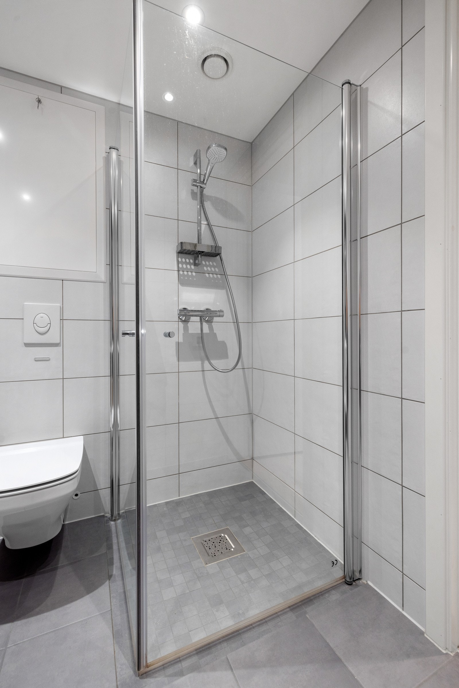 Badet er utstyrt med svingbare dusjvegger og termostatstyrt dusjbatteri i krom Galleribilde