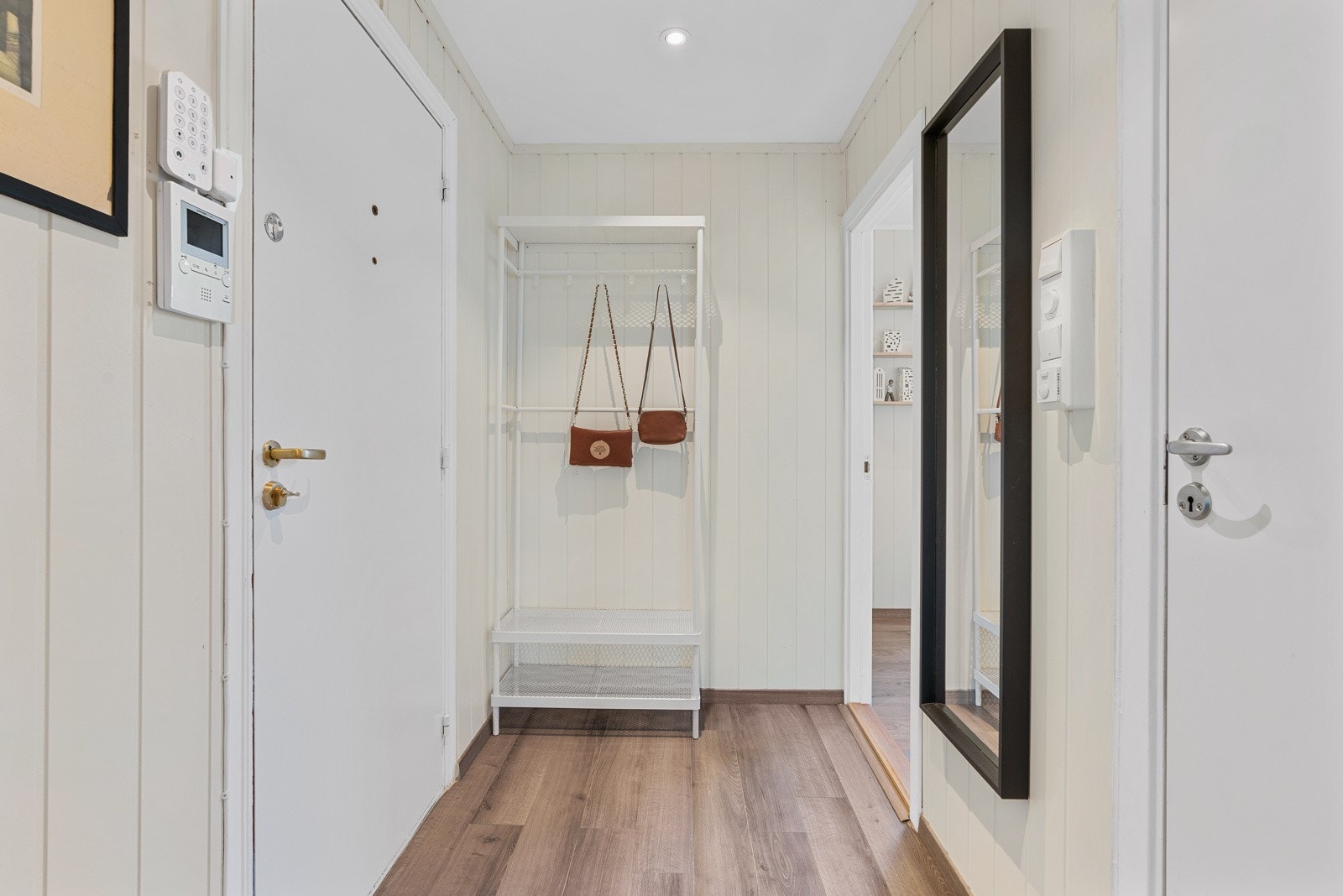 Entreen har lysmalte panelvegger, samt enstavs laminatgulv og hvitmalt, glatt himling med downlights. Galleribilde