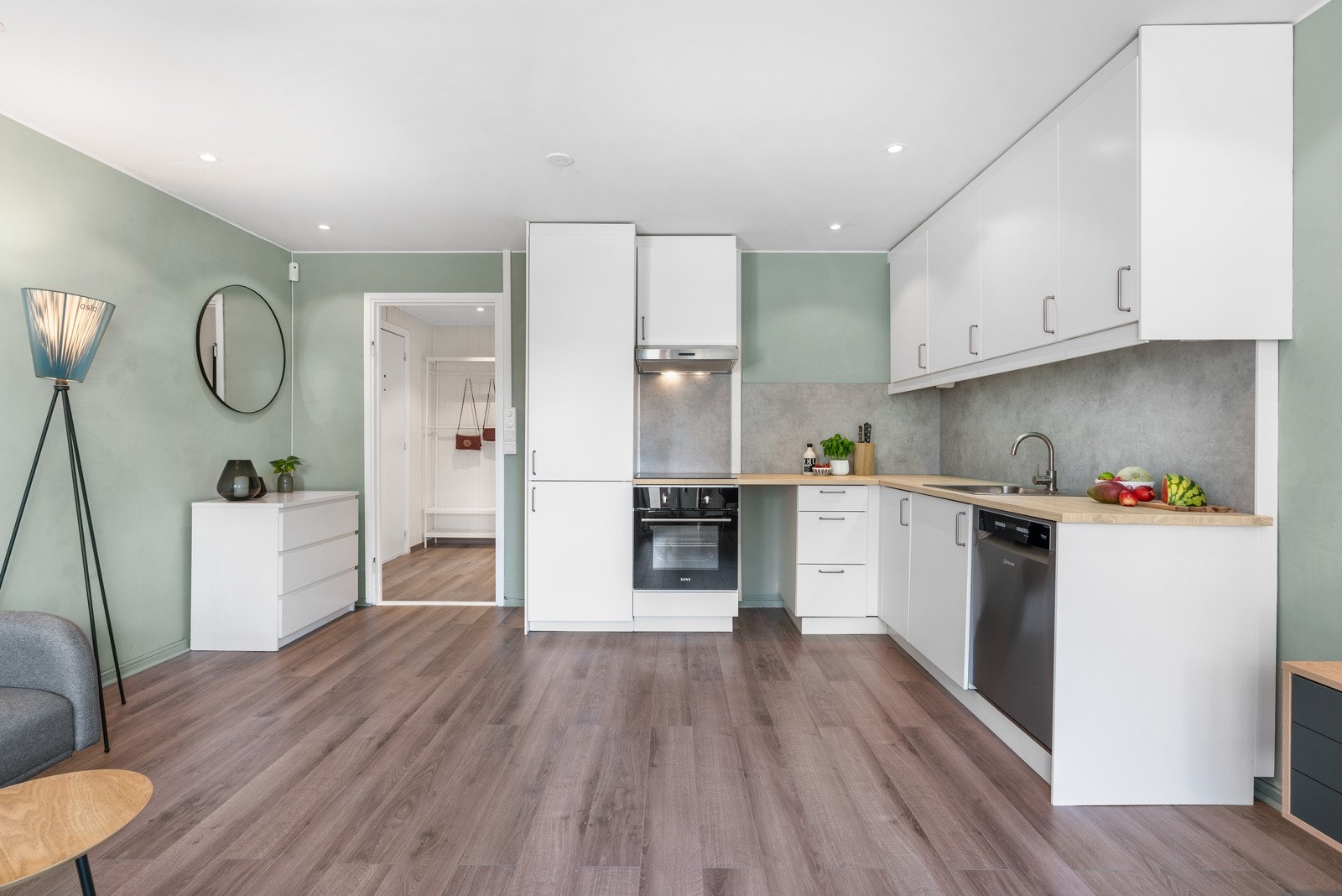 Innredningen fra Ikea har takoppforede skap, hvite, glatte fronter og benkeplate i trehvit laminat med nedfelt vaskekum. Galleribilde