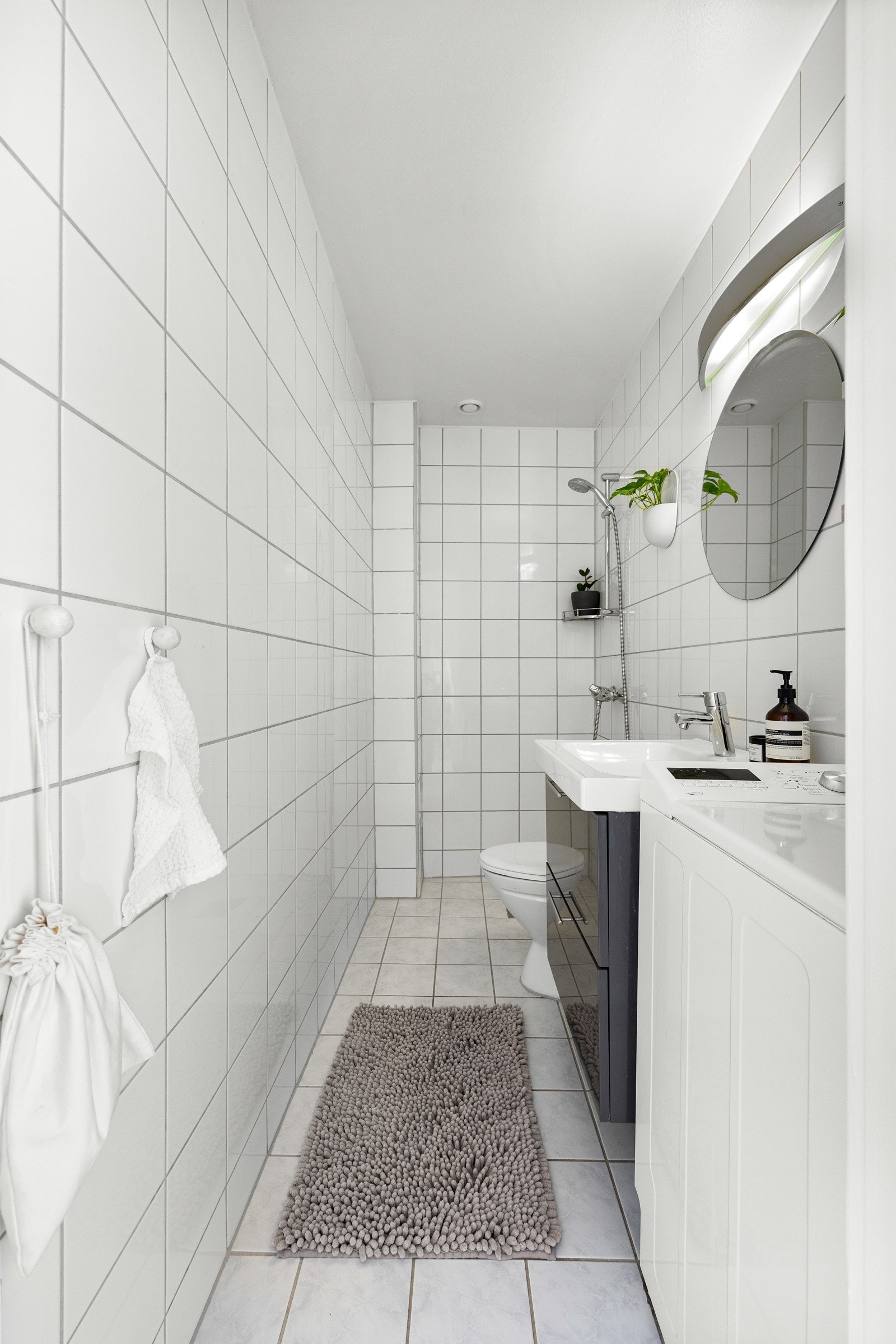 Badet er utstyrt med gulvstående toalett, dusjnisje og servant. Vaskemaskinen medfølger salget. Galleribilde