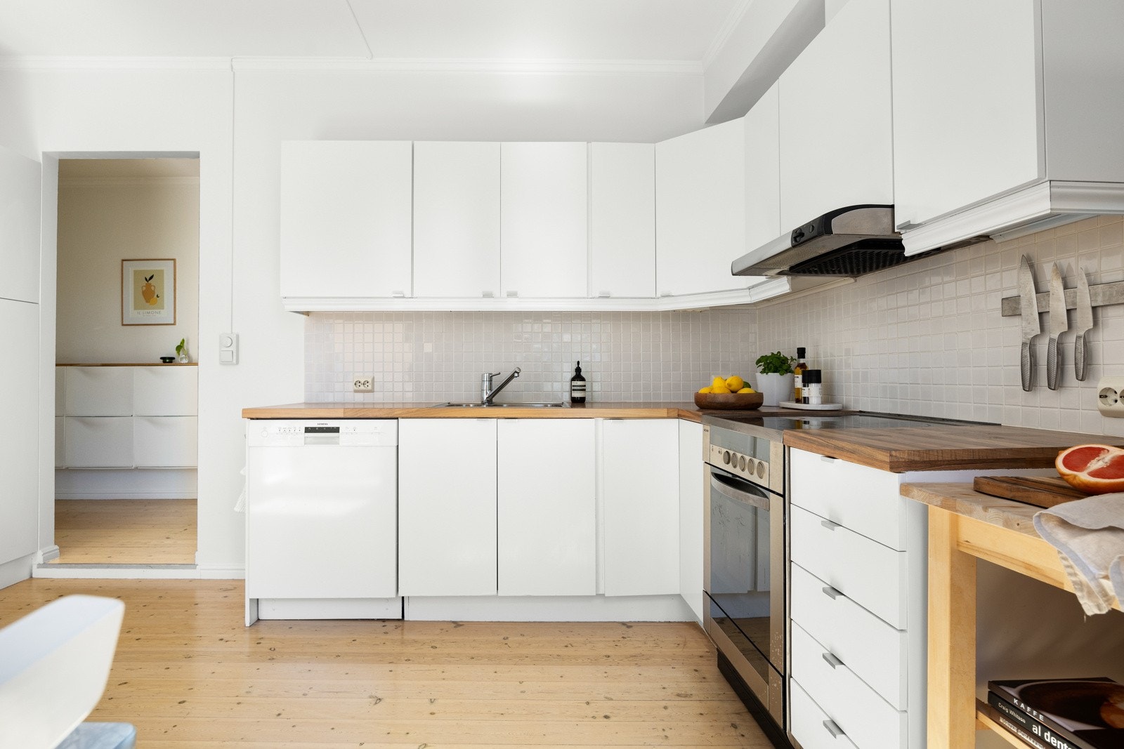 Innredningen har glatte fronter, belysning under overskap og solid laminat benkeplate. Galleribilde