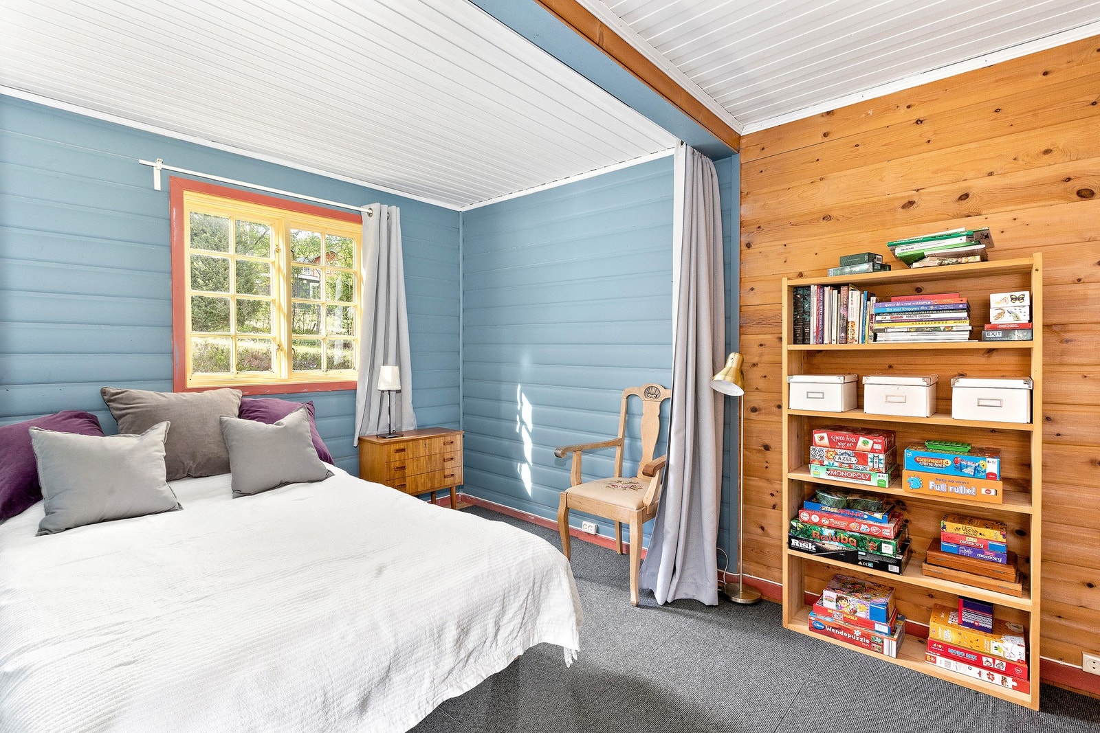 I enden av stua er det satt inn en seng med forheng. Rommet er pent brukt til både sovealkove og lekerom. Galleribilde