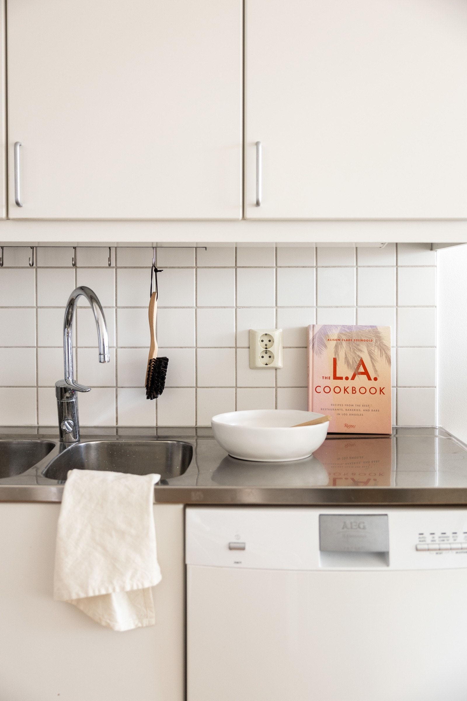 Mellom kjøkkenbenk og overskap er det fliser, og det er benkeskapsbelysning og stikkontakter over kjøkkenbenken. Galleribilde