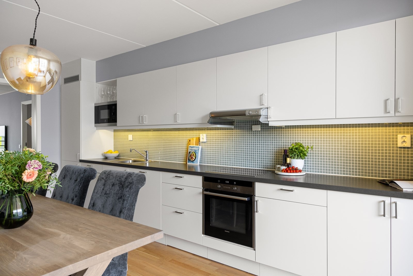 Kjøkkenet har glatte fronter og laminat benkeplate med nedfelt kum. Galleribilde