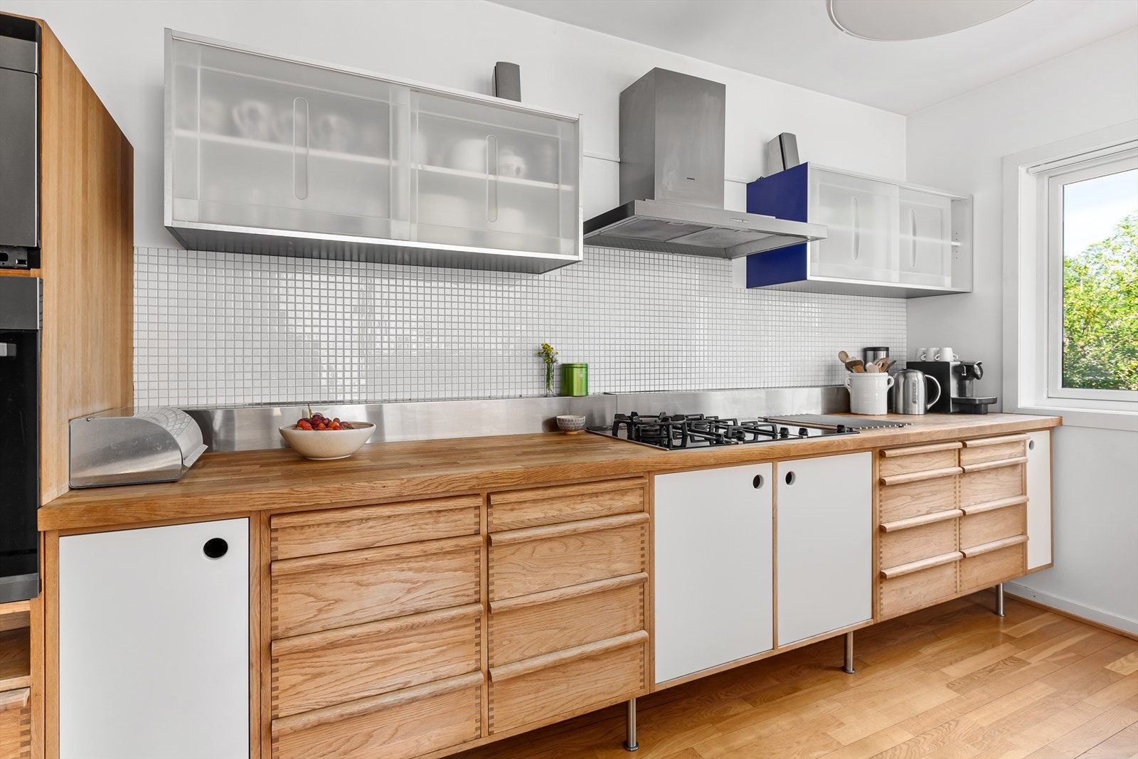 Kjøkkenet har heltre eik skuffer og hvite glatte skapfronter Galleribilde