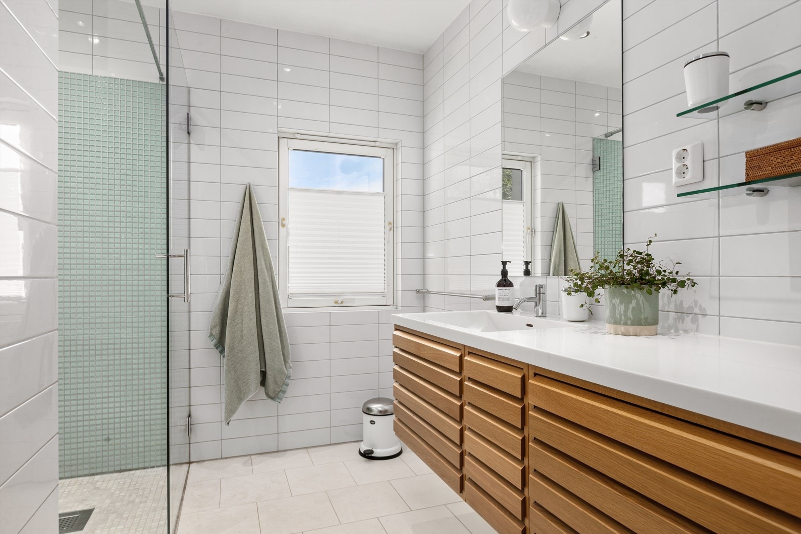 Delikat bad i 2. etasje med med innmur badekar, dusjhjørne, servant, speil og godt med skuffer. Galleribilde