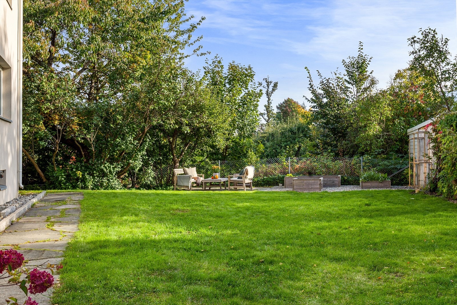 Pent opparbeidet hage med plass til sittegrupper, grill, solsenger og lek for hele familien. Galleribilde