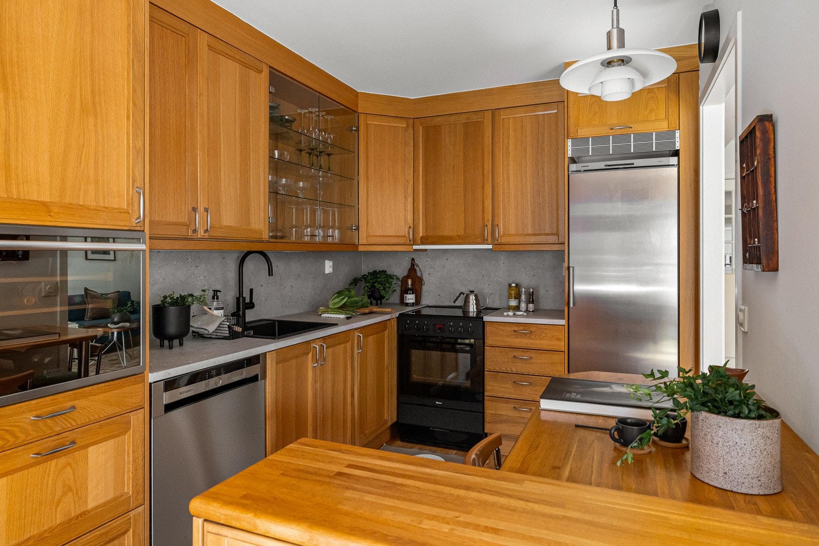 Det pene eikekjøkkenet er utstyrt med hvitevarer som komfyr med keramisk platetopp (Gram), oppvaskmaskin med synlig front (Grundig) og kjøleskap (Siemens) Galleribilde