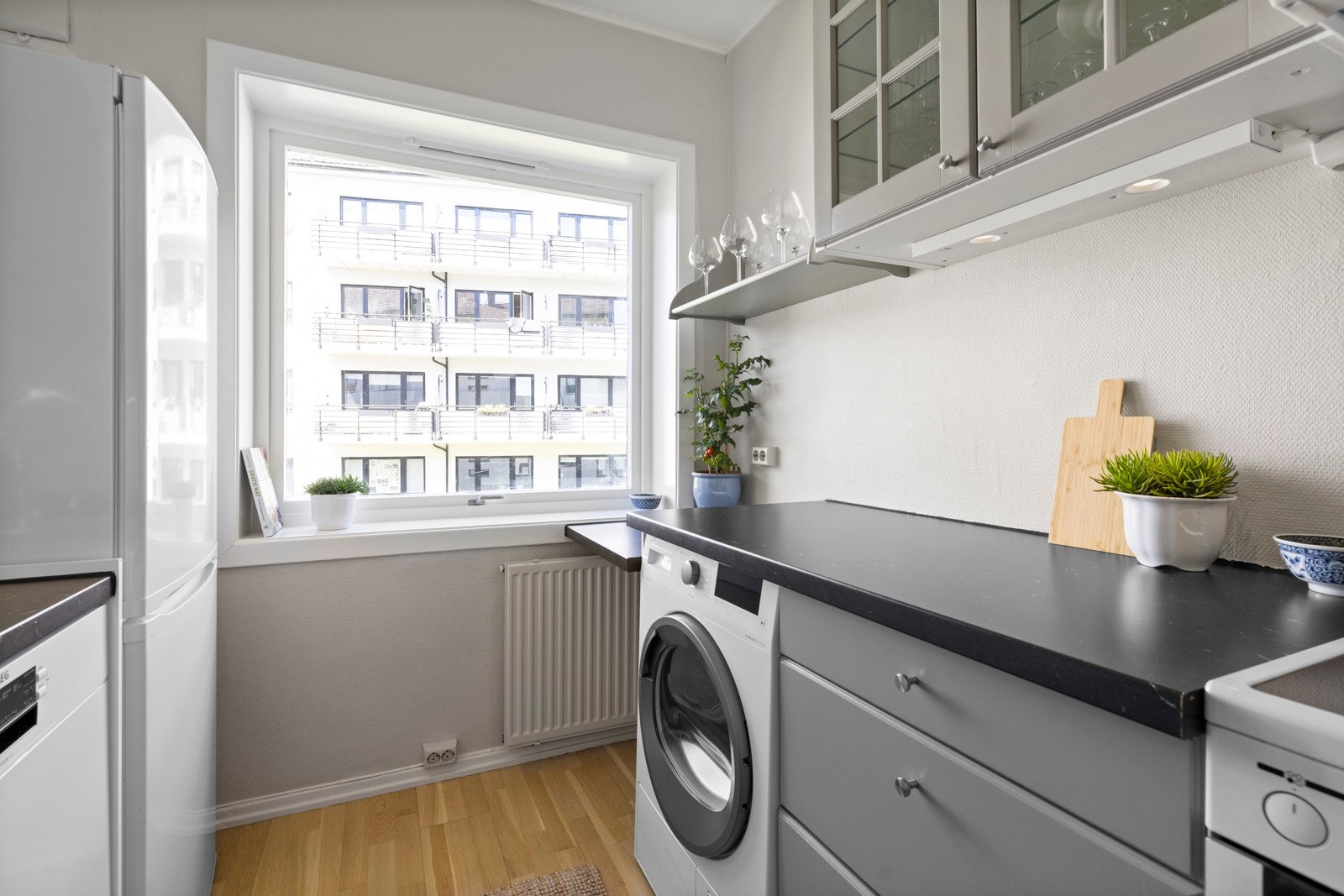 Kjøkkenet har opplegg for oppvaskmaskin, tørketrommel og komfyr med topp og frittstående kjøleskap Galleribilde