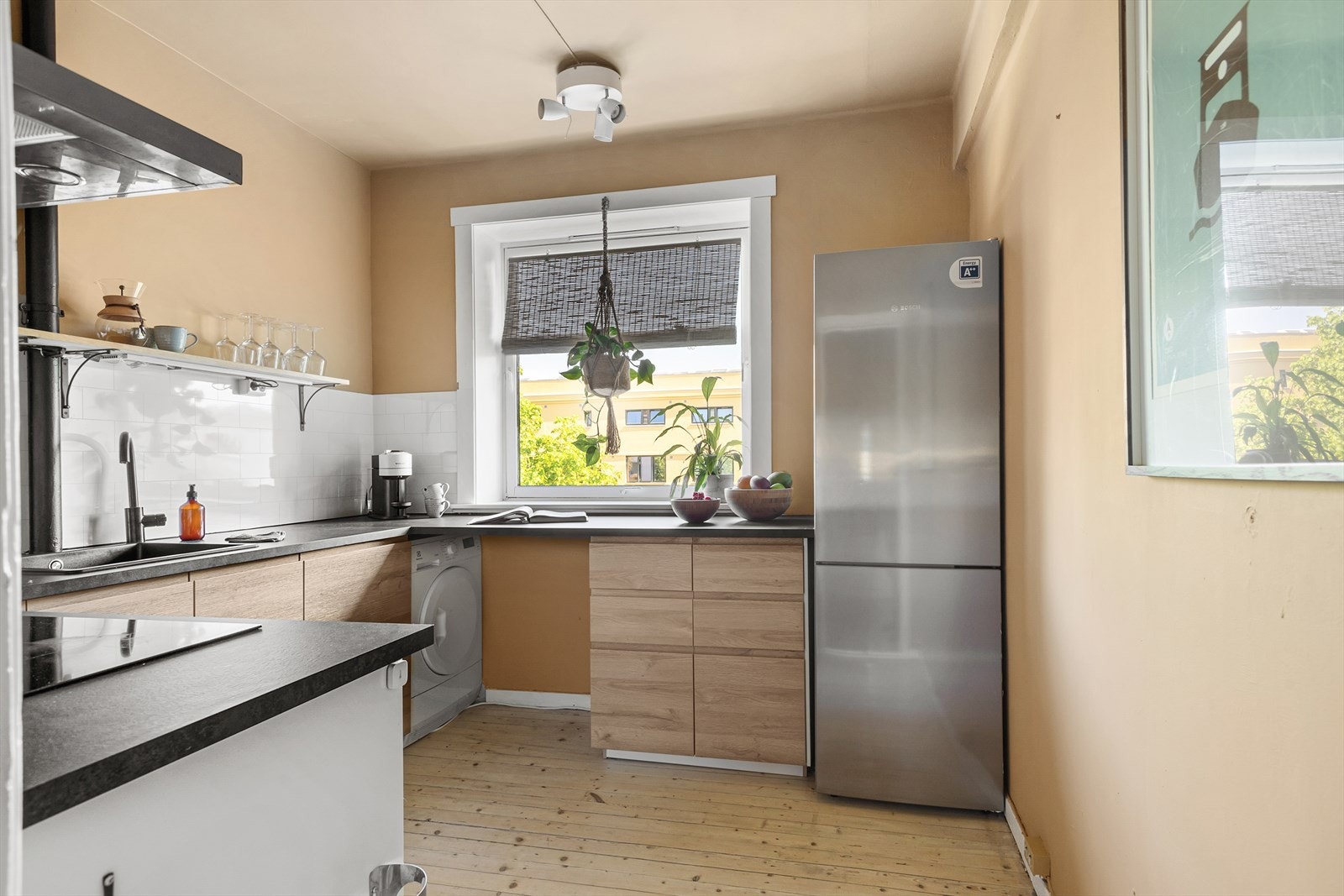 Lekkert kjøkken fra IKEA med innredning med glatte fronter, laminat benkeplate, nedfelt oppvaskkum og frittstående kjøl/fryseskap Galleribilde